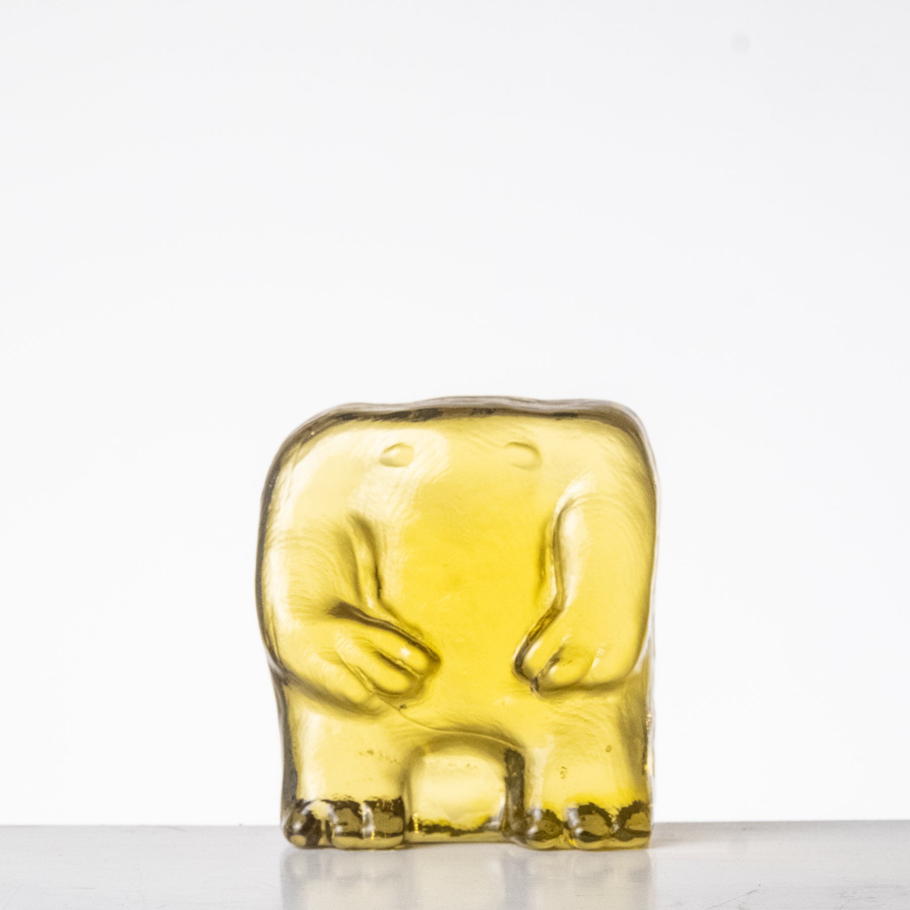 Yellow glass figurine on a white background