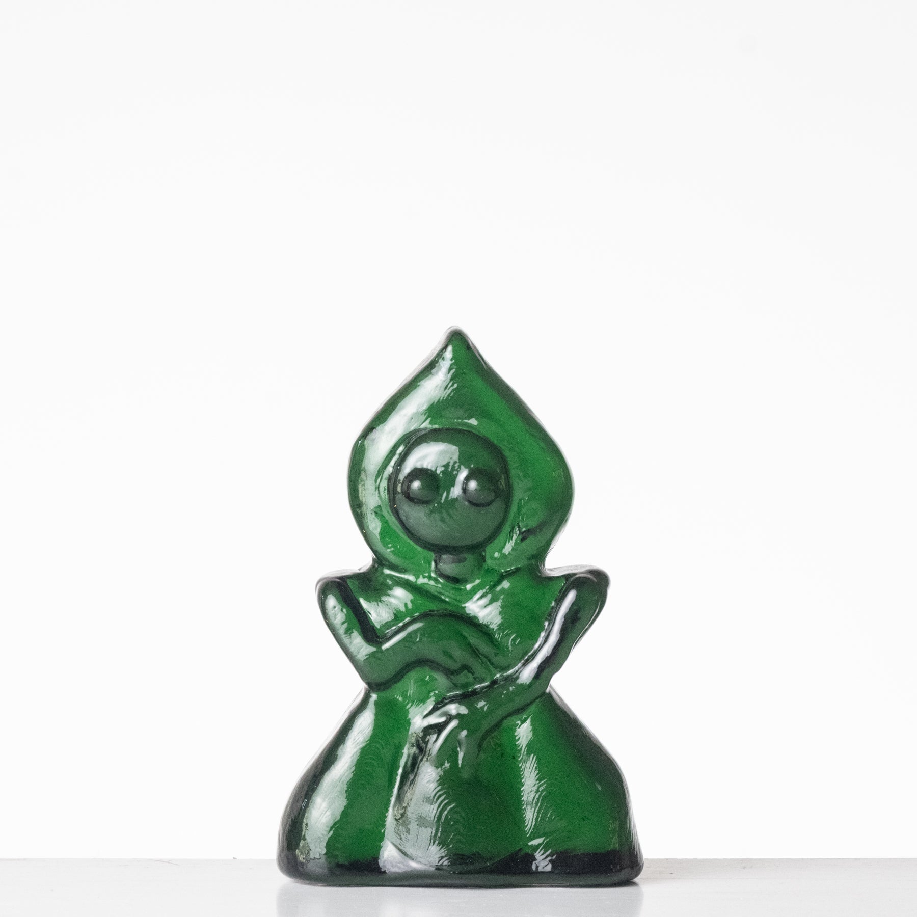 Green alien figure with a hood on a white background