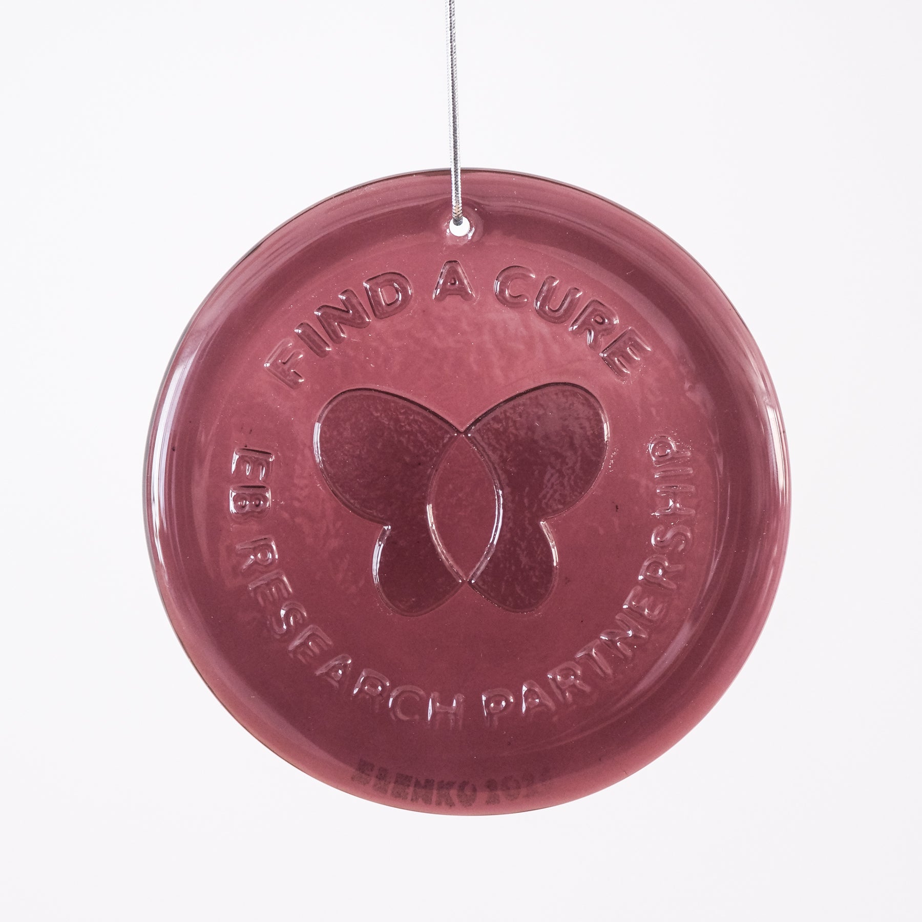 Round pink ornament with 'Find a Cure' and butterfly design on a white background
