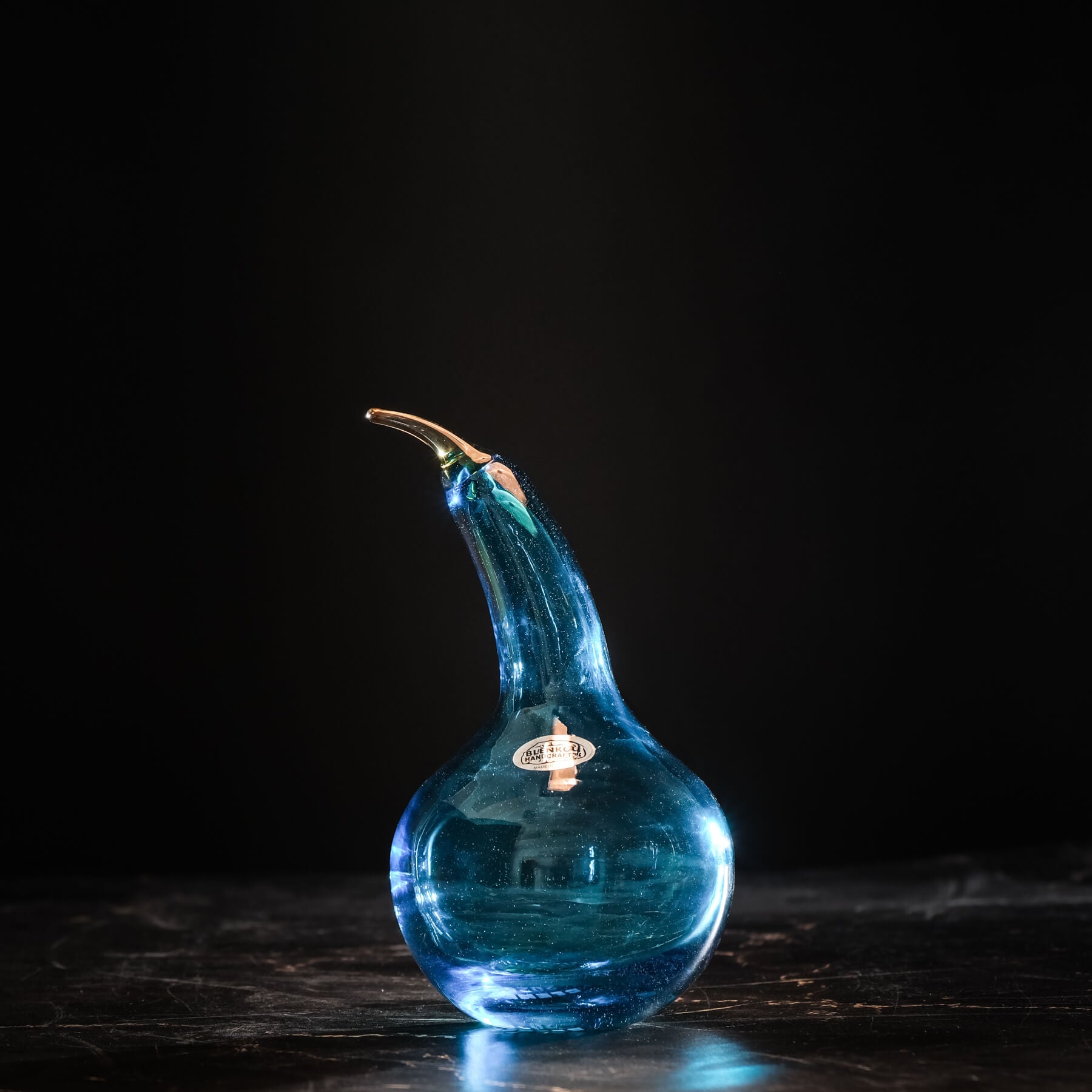 Blue glass vase with a unique shape on a dark background