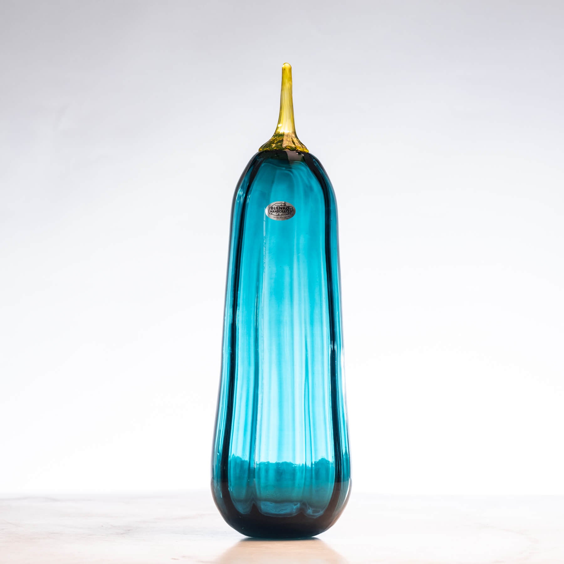 Blue glass tall pumpkin with a yellow stem on a white background