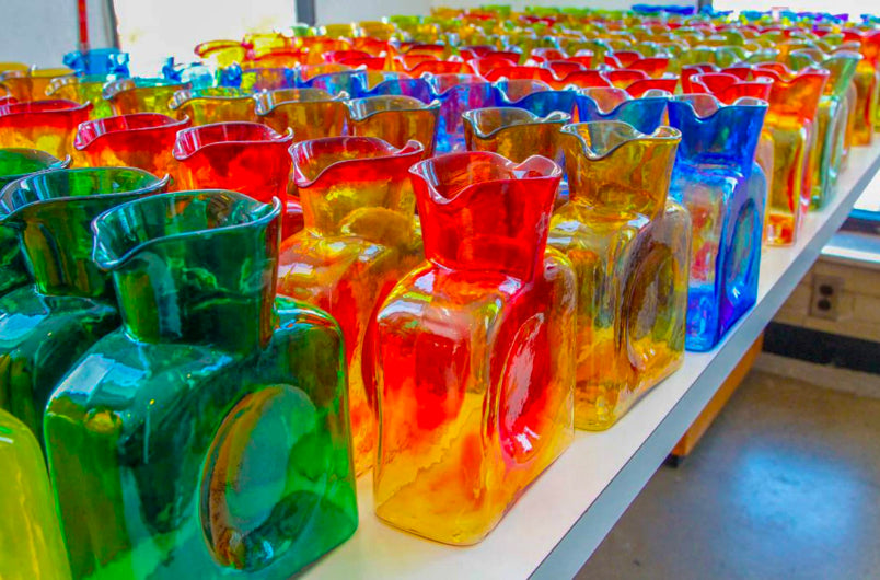 Our Story - image of Blenko 384 water bottles on a white shelf.