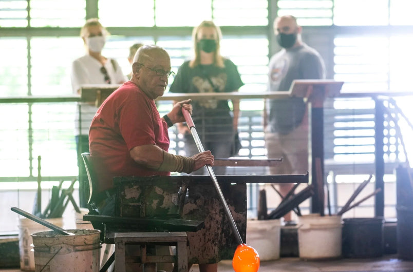 Man with blow pipe working in the Blenko Glass factory.