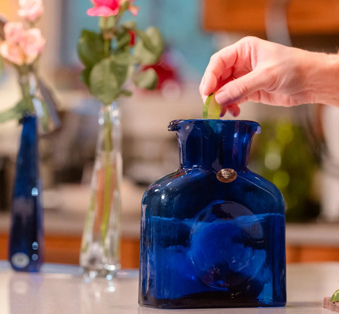 Hand squeezing lime into cobalt water bottle