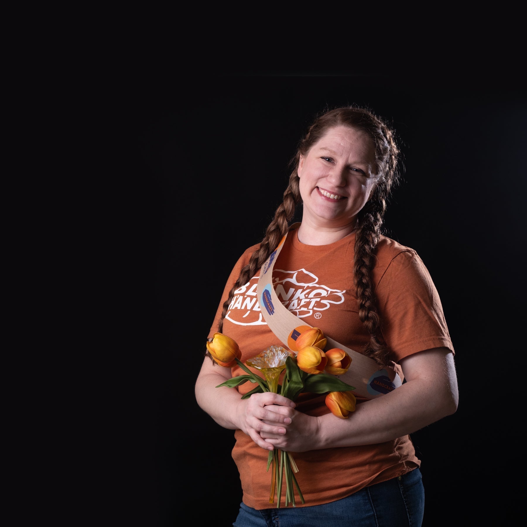 Woman with flowers and orange shirt on a black background