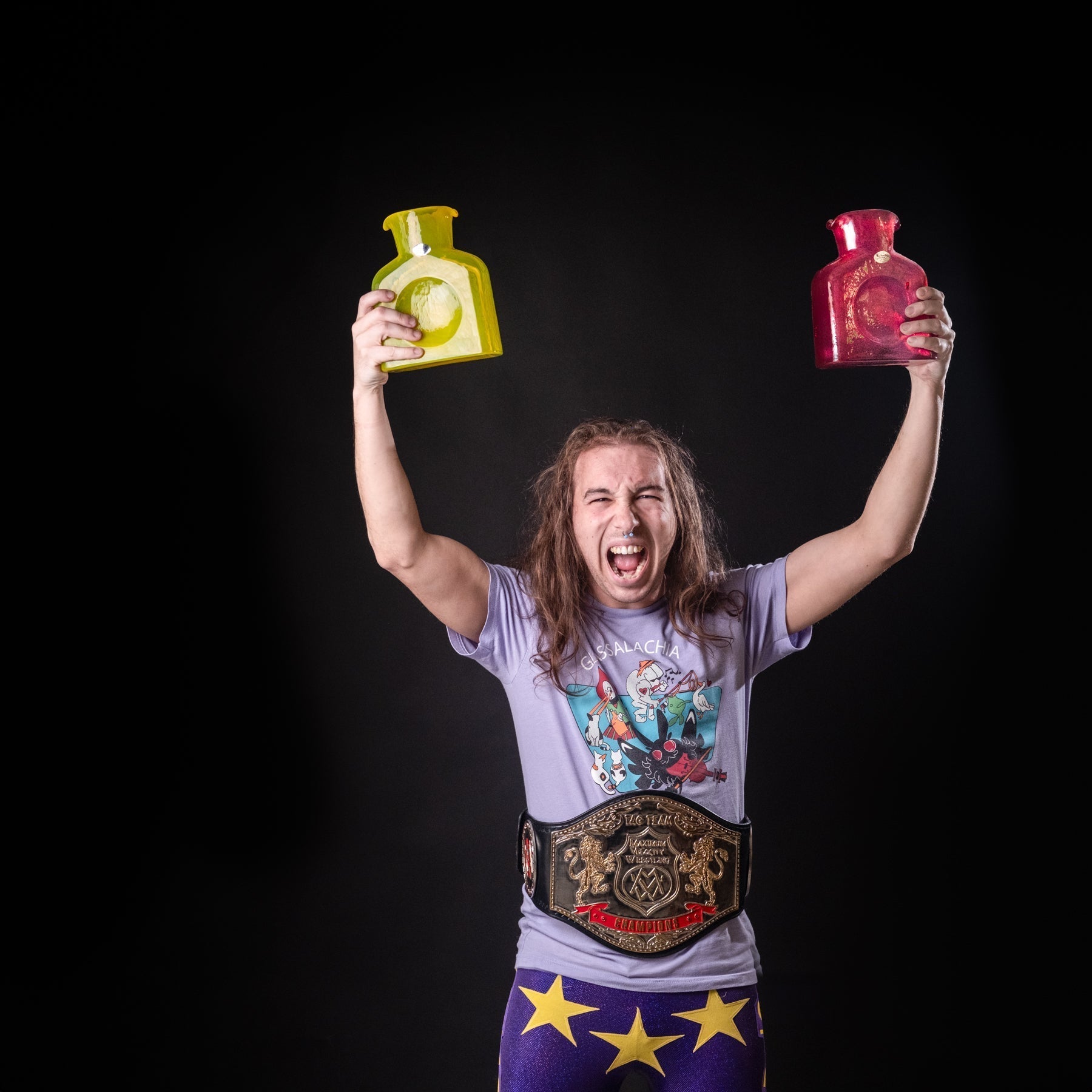 Person holding a yellow and red bottle against a black background