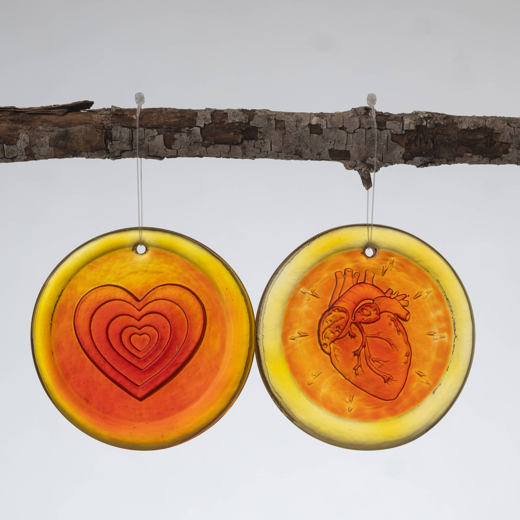 2 Heart' Suncatcher in Tangerine hanging one a stick.