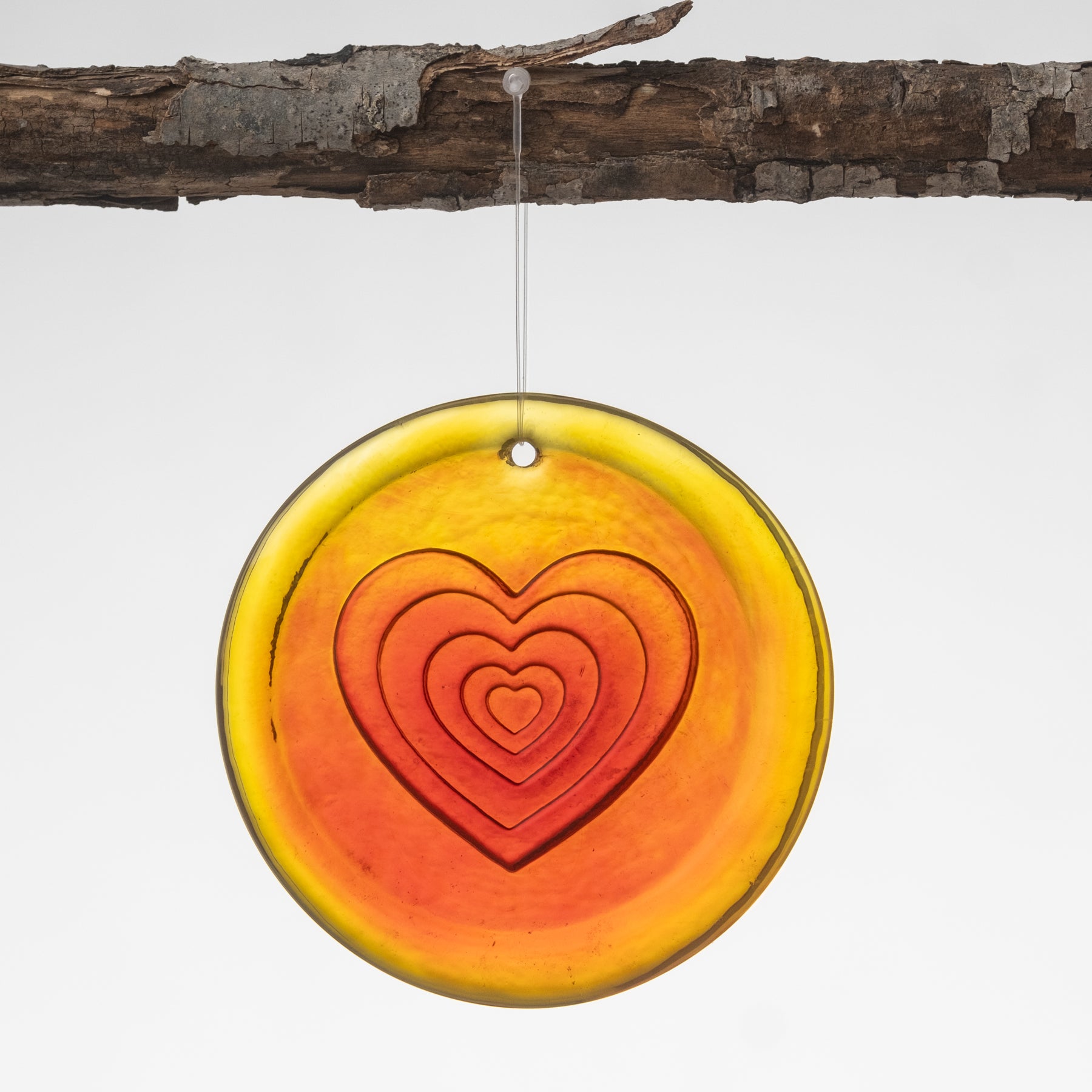 tangerine Sun-catcher with a layered heart  on it.