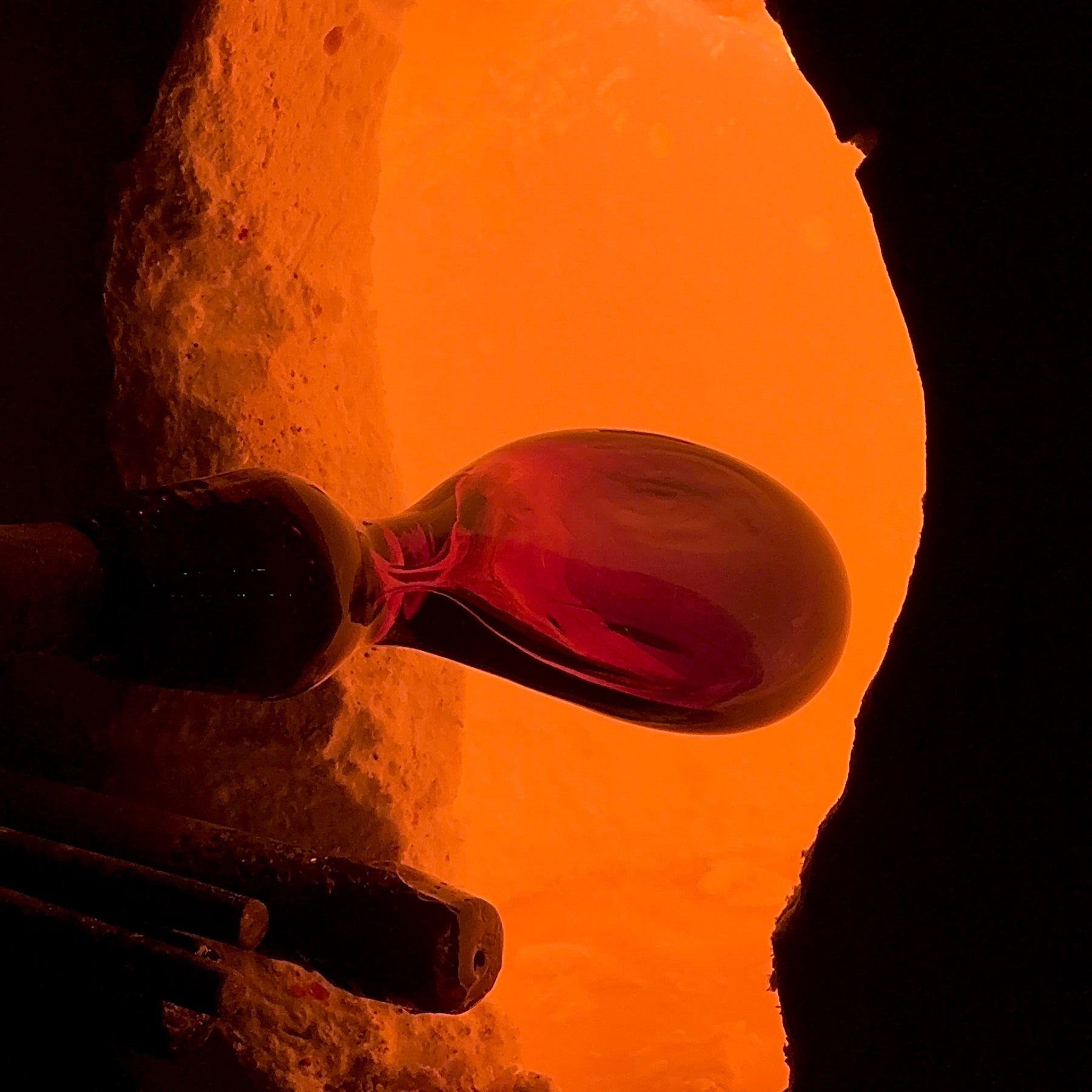 Close-up of a person holding a small object with a bright orange background