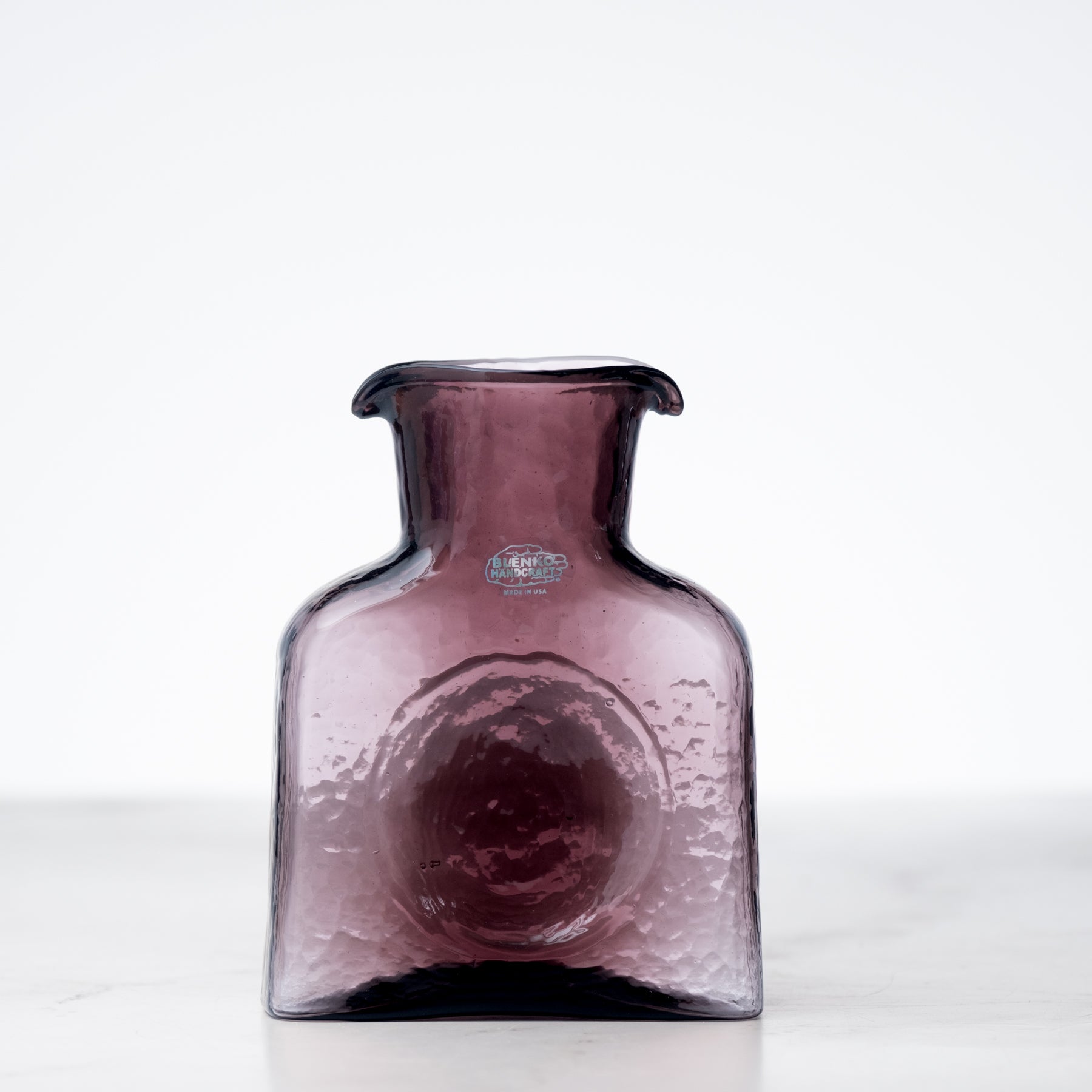 Purple glass vase on a white background