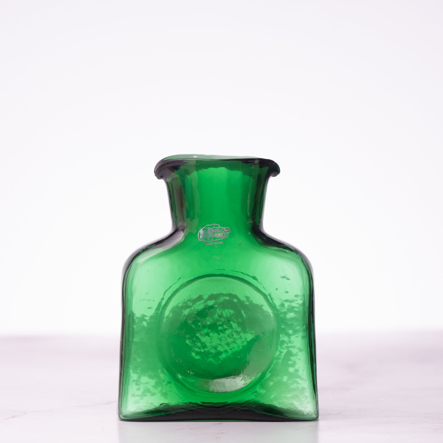 Green glass bottle on a white background