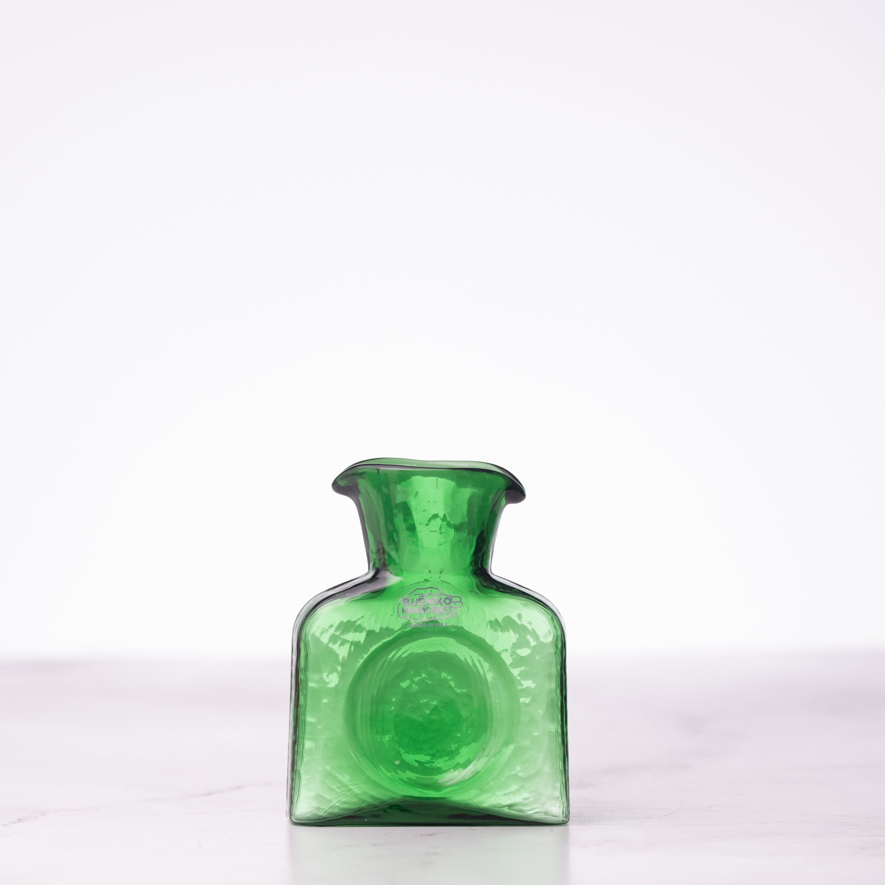 Green glass bottle on a white background