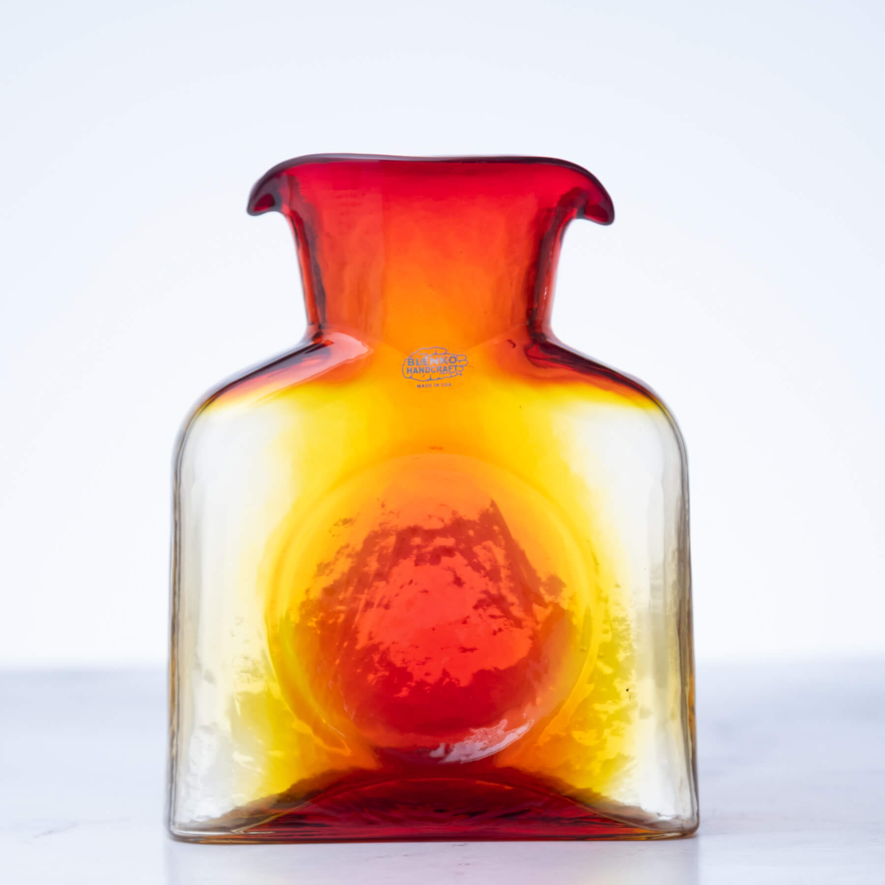 Glass vase with red and yellow gradient on a white background