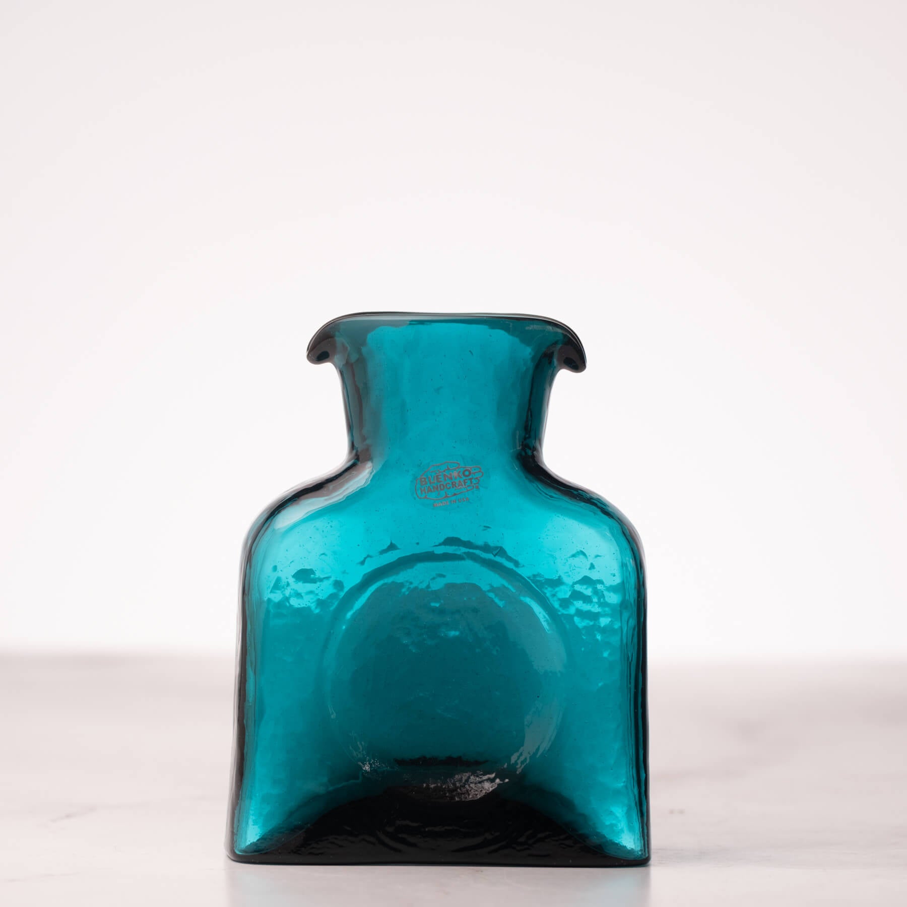 Teal glass bottle on a white background