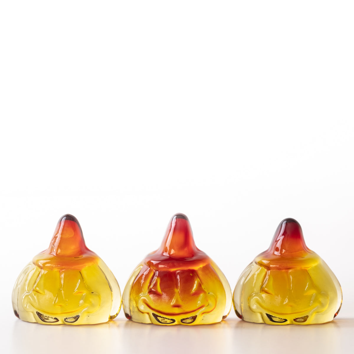 Glass pumpkin figurine with a smiling face on a white background