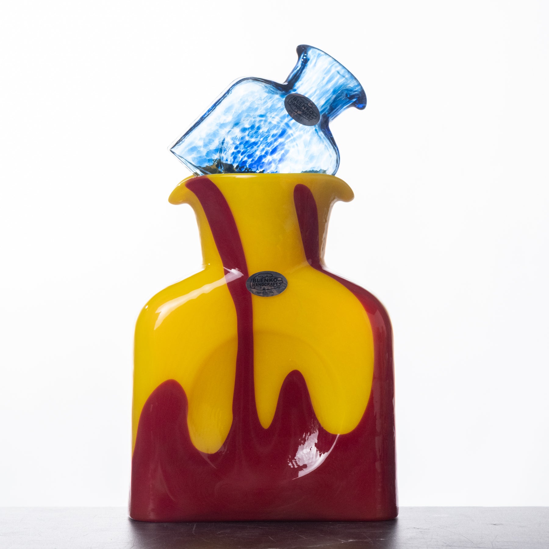 Glass decanter with red and yellow design on a white background