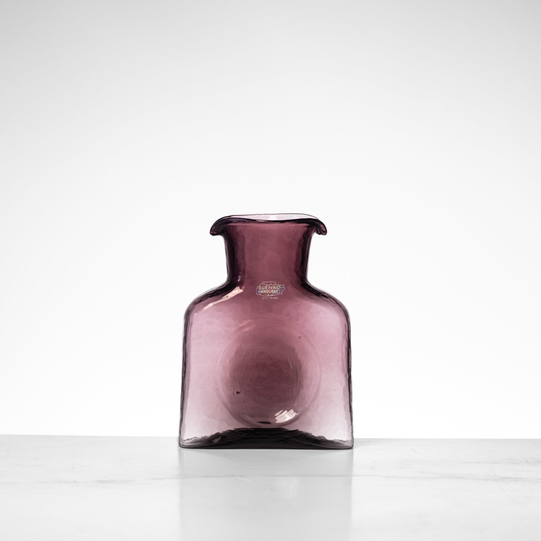 Purple glass vase on a white background