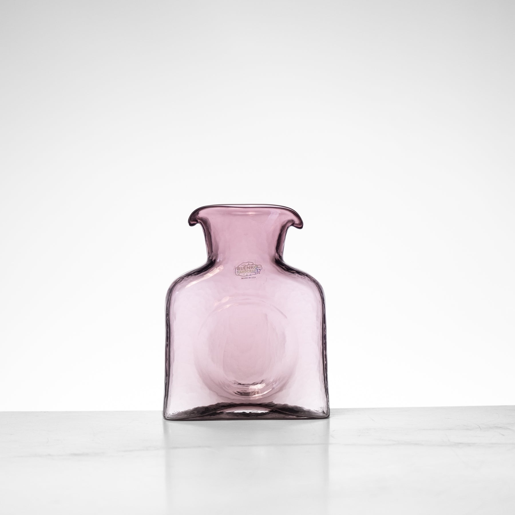 Pink glass vase on a white background