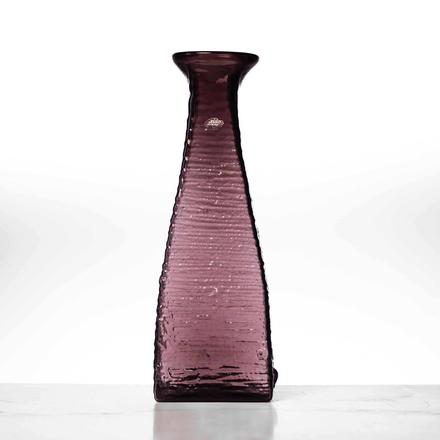 Purple glass vase on a white background