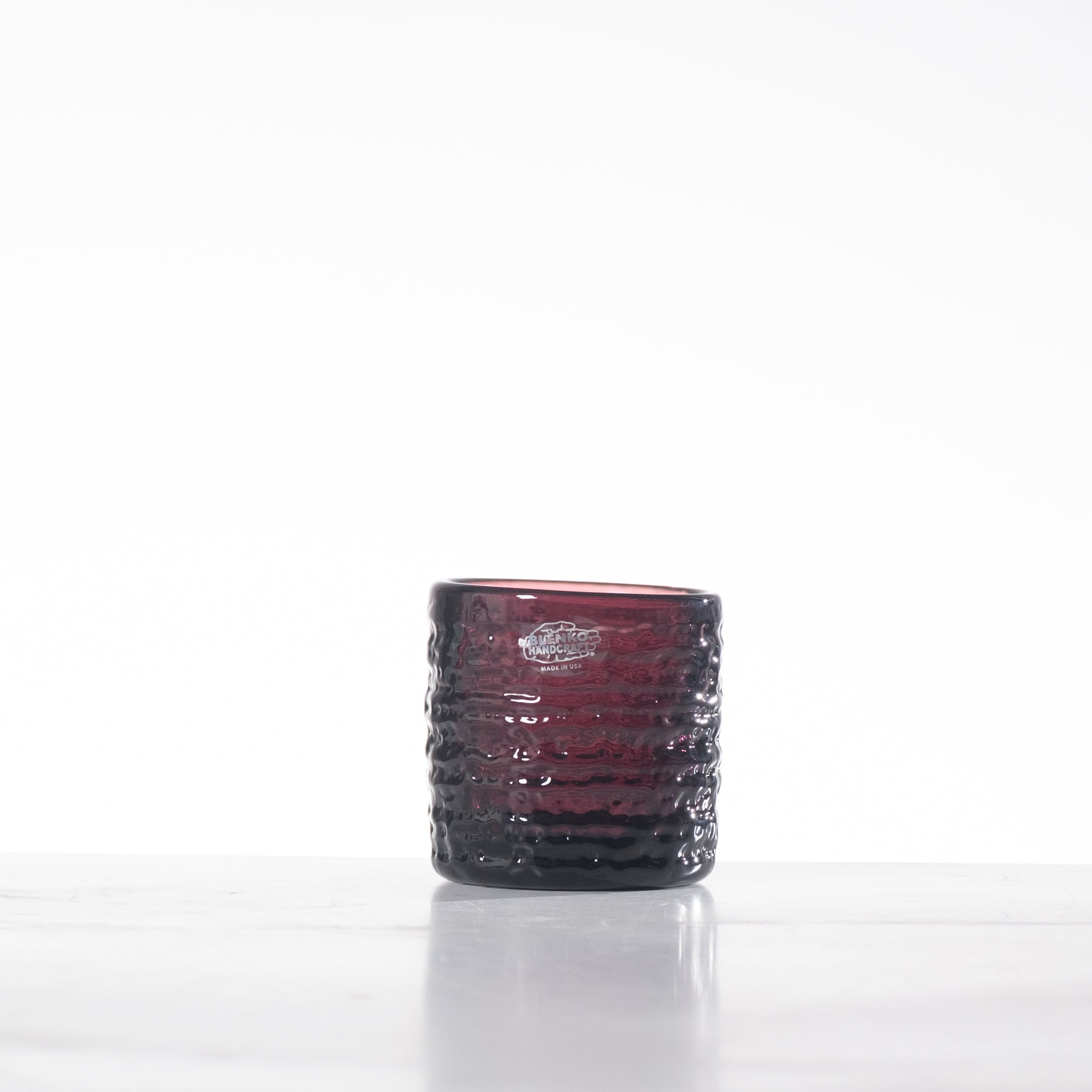 Red textured glass candle holder on a white background