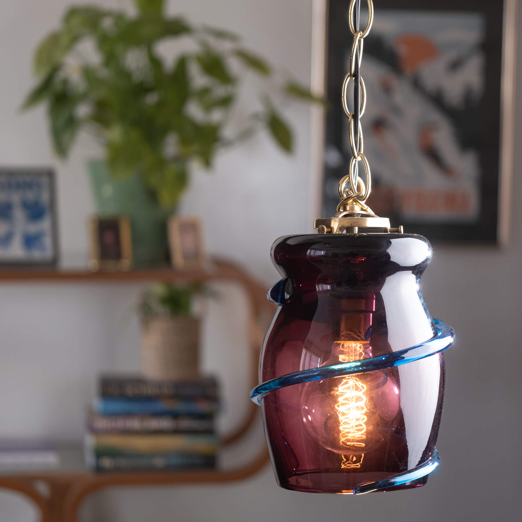 Amber glass pendant light with visible bulb in a home setting