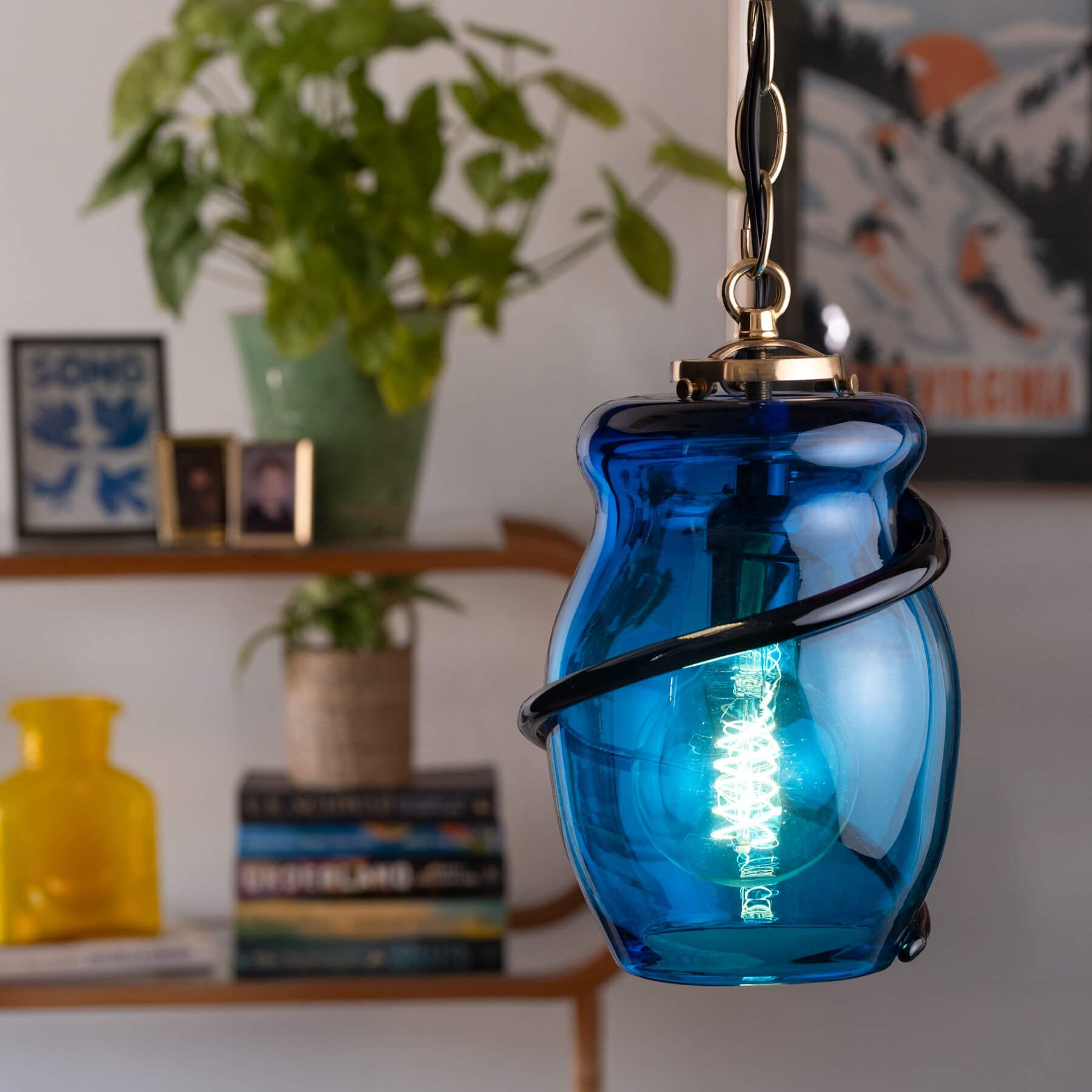 Blue glass pendant light with a blurred indoor background