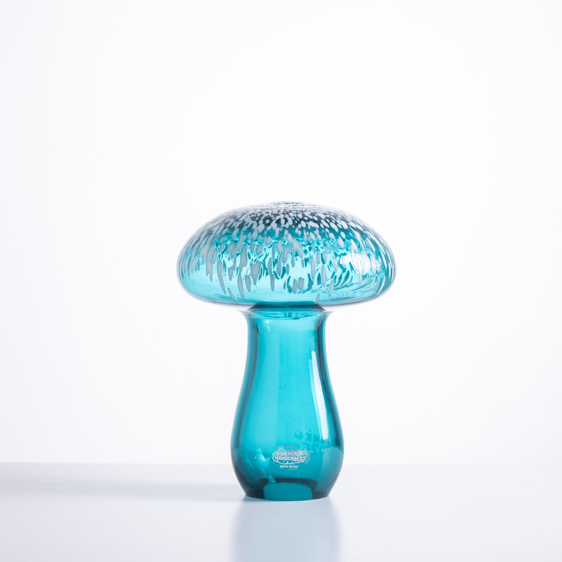 Blue glass mushroom-shaped object on a white background