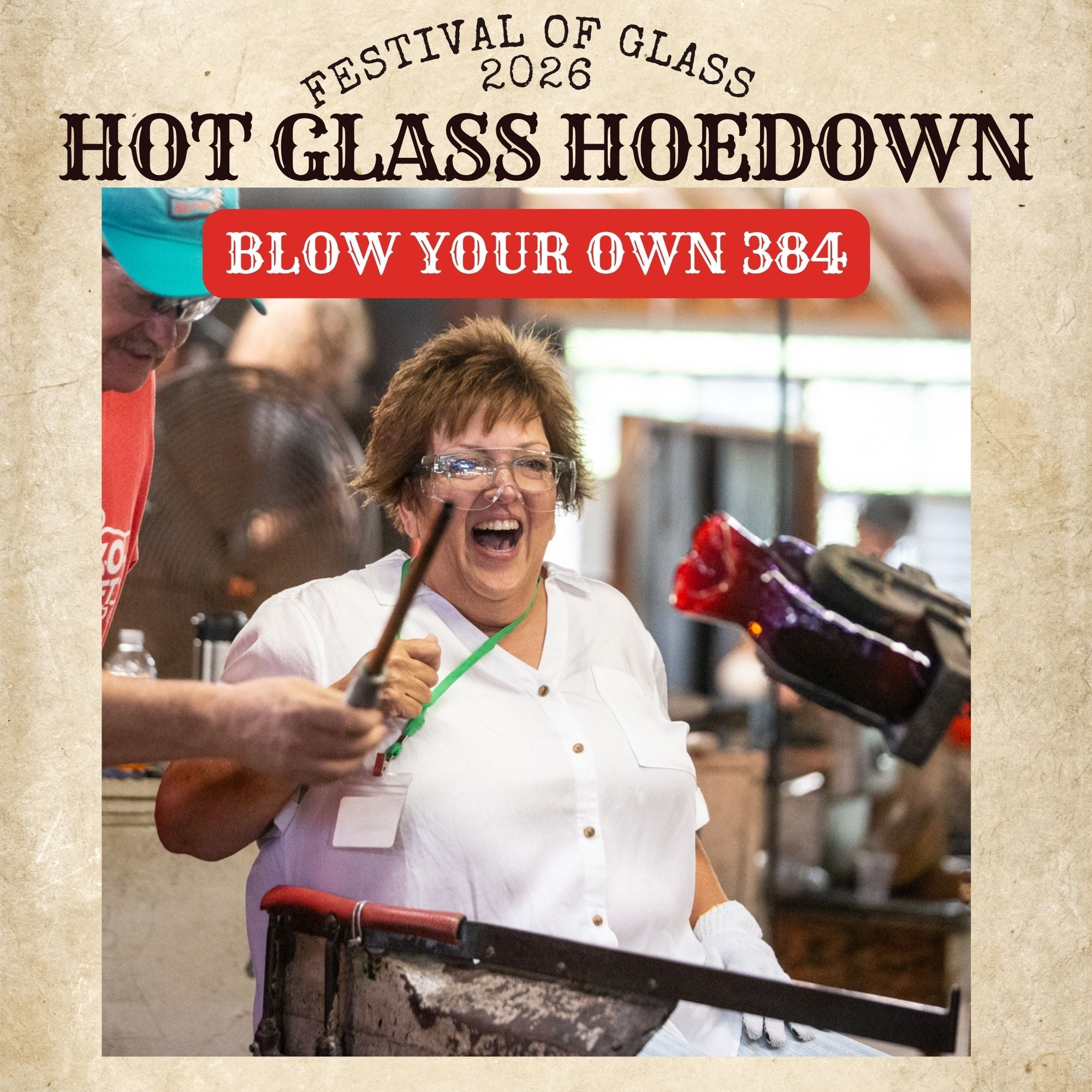 Person blowing glass at a glass blowing event with text 'Hot Glass Hoedown' and 'Festival of Glass 2026'.