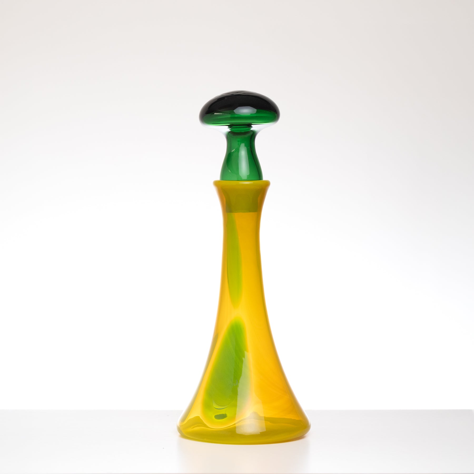 Colorful glass bottle with green and yellow design on a white background