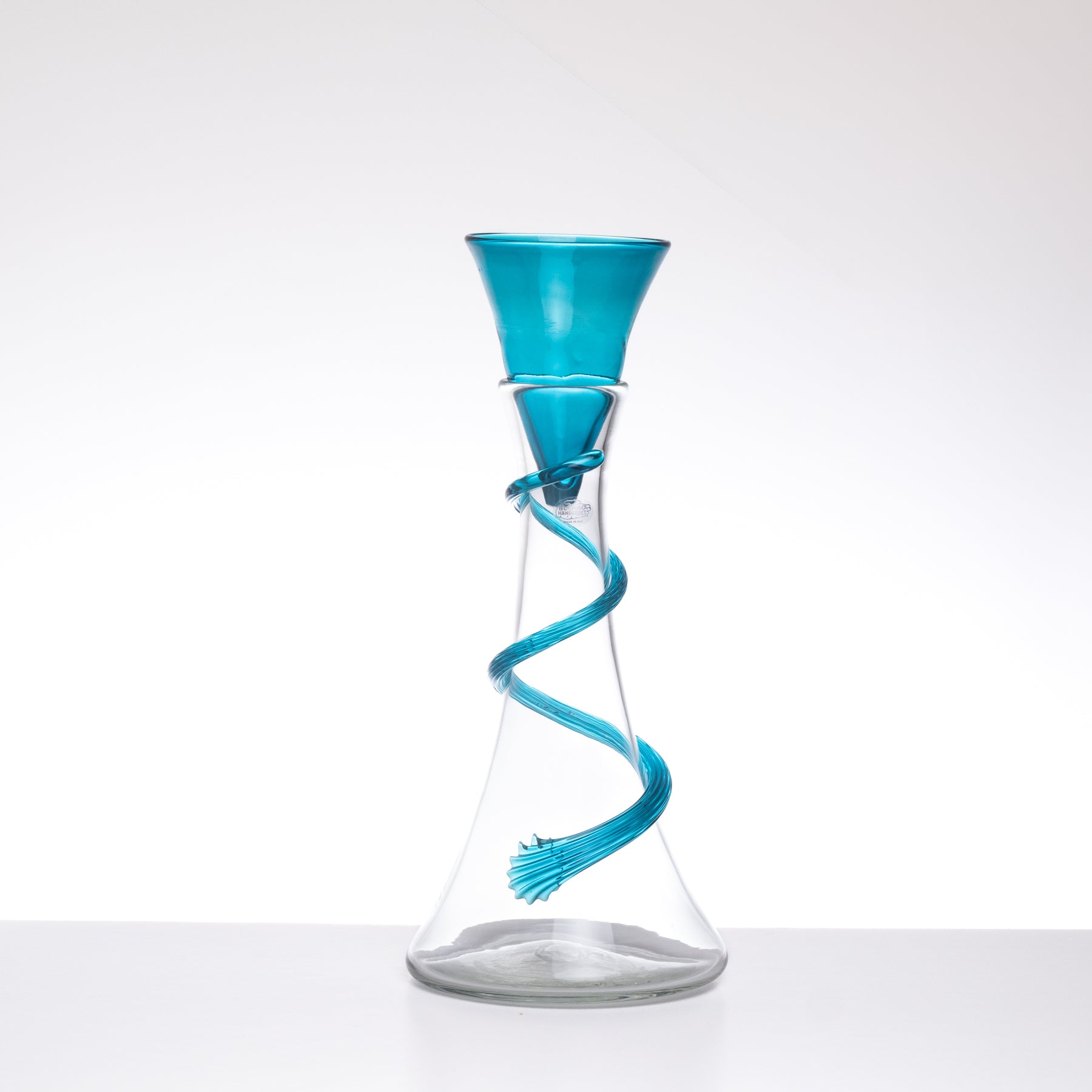Glass carafe with a blue spiral on a white background