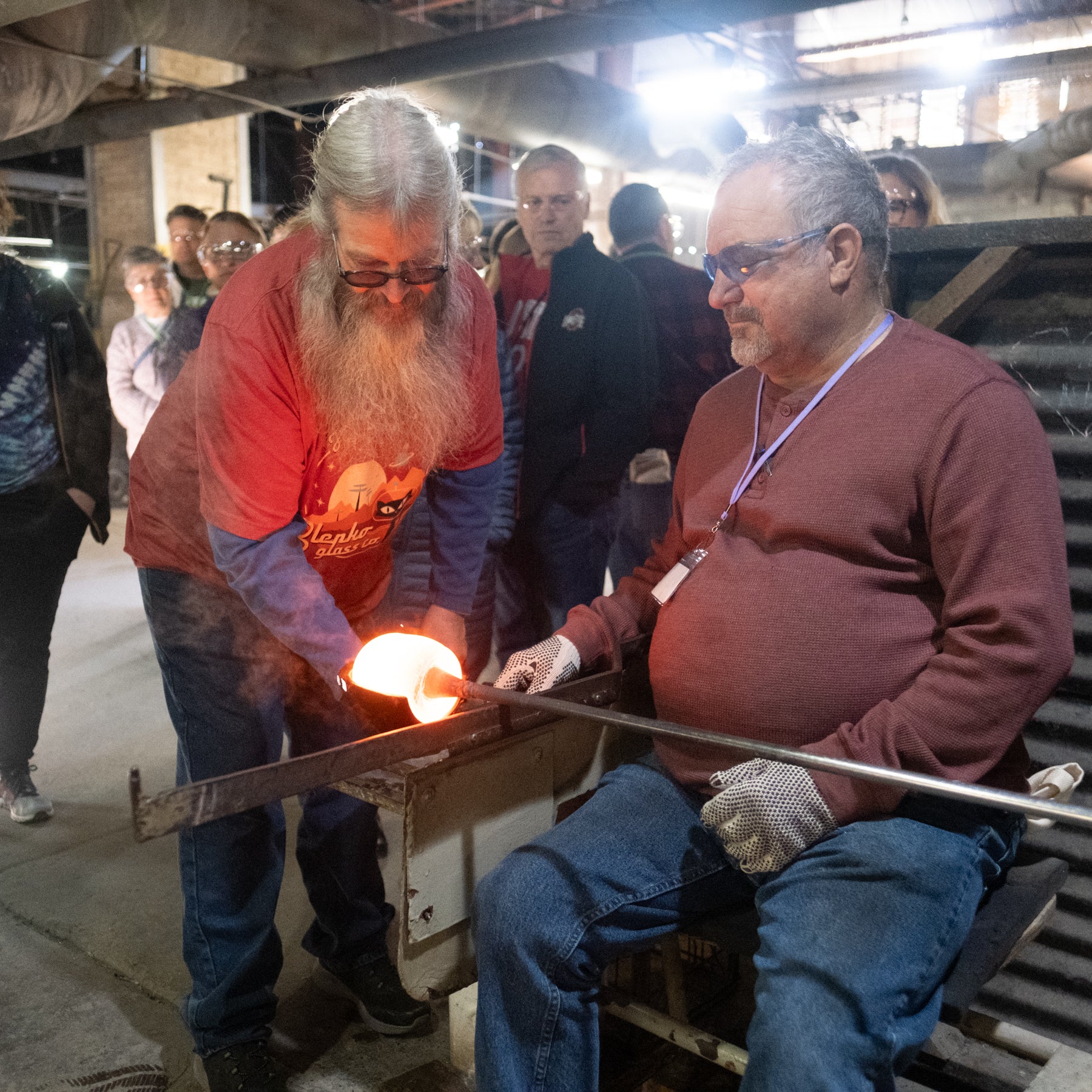 Two men working with a glowing object in an industrial setting