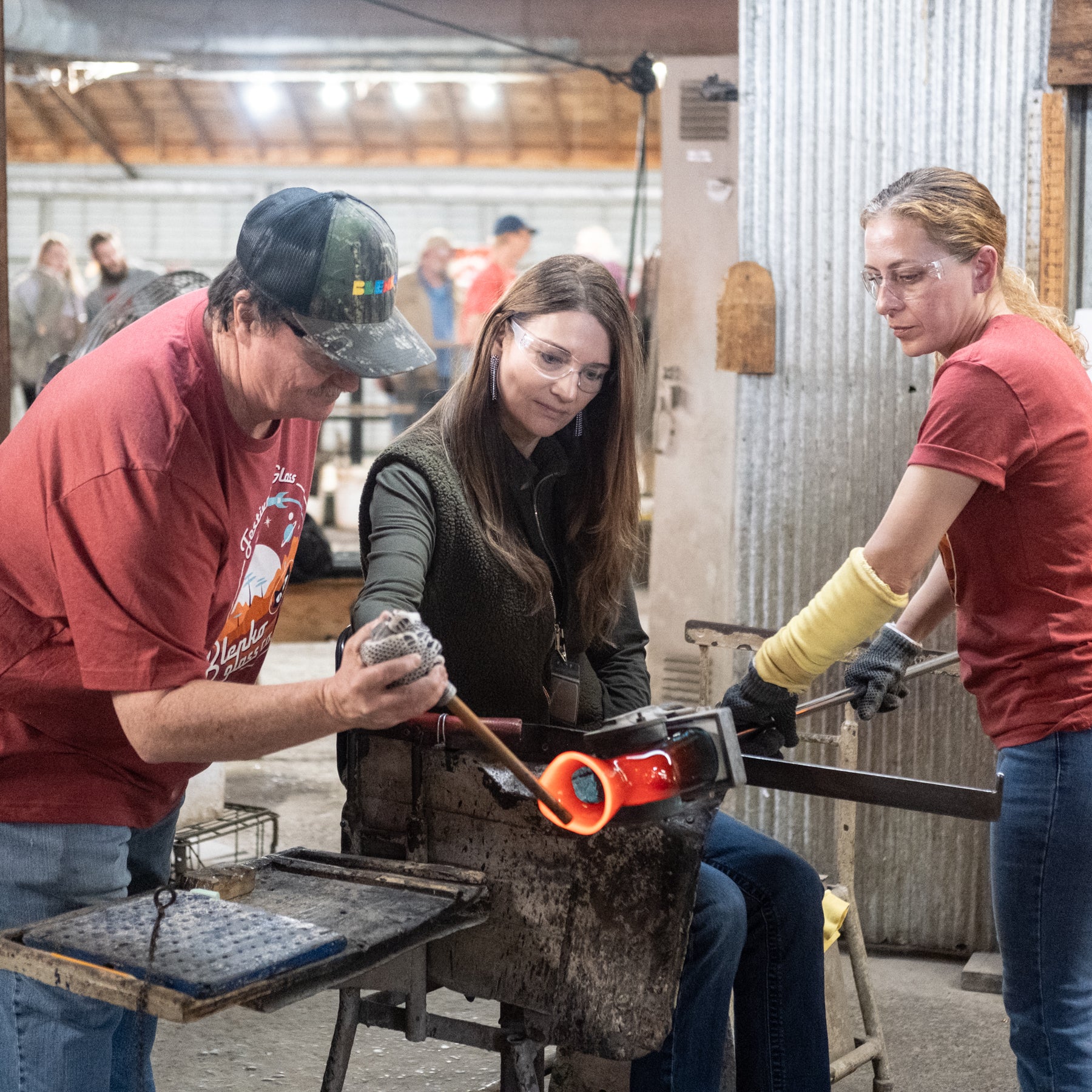Three people working together in a workshop setting.