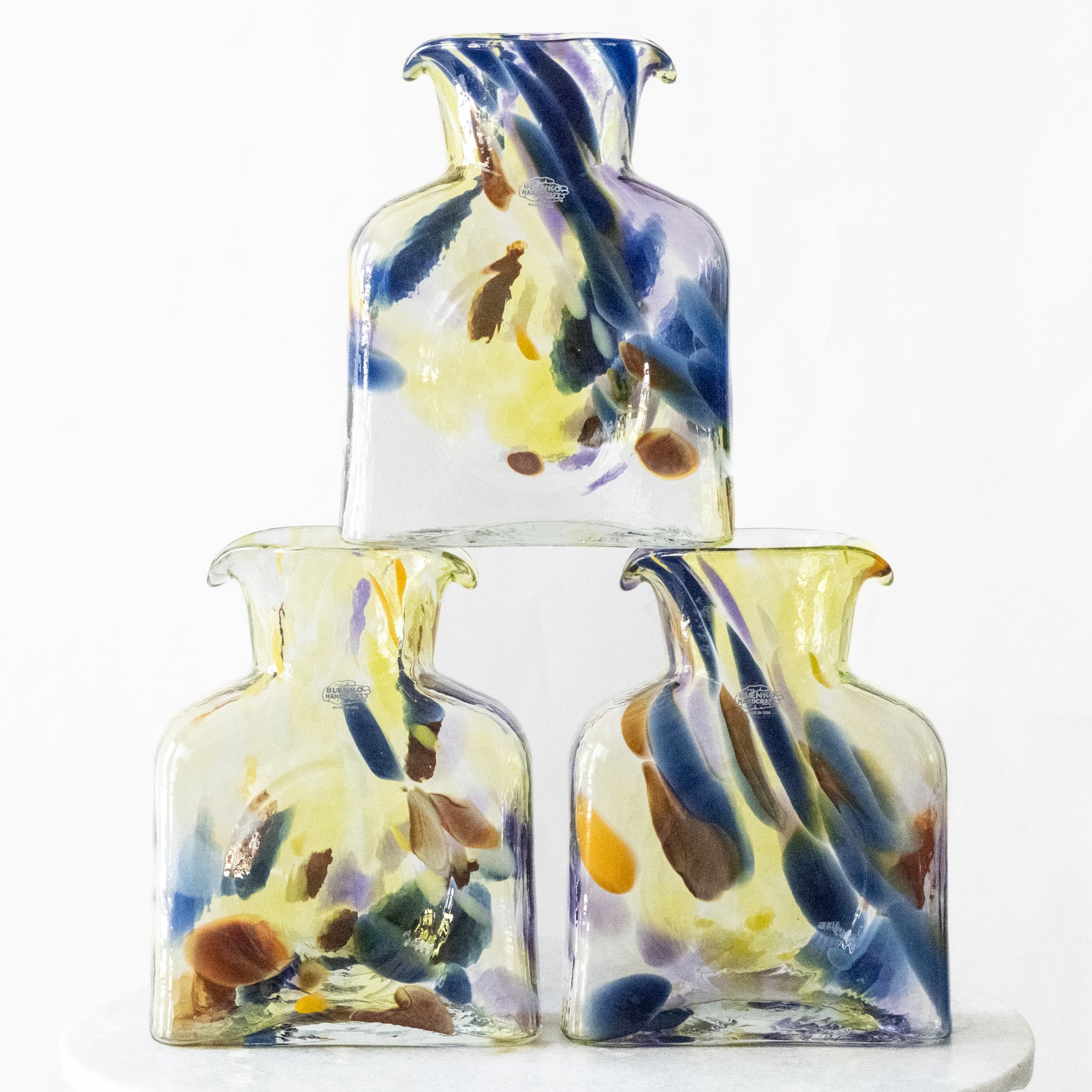 Set of three colorful glass vases on a white background