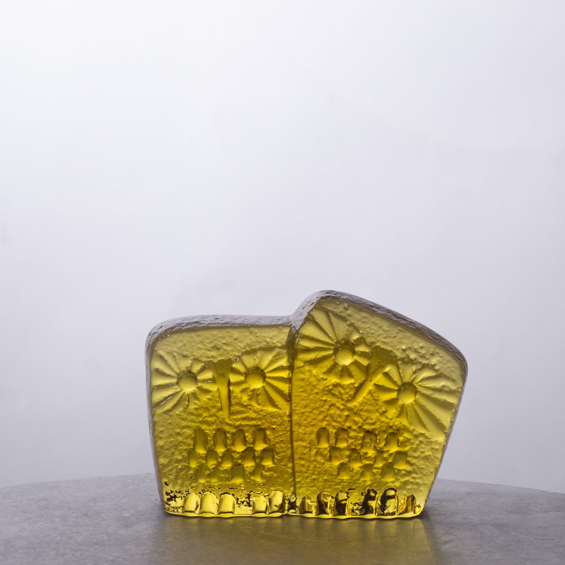 Two yellow glass blocks with textured surface on a white background