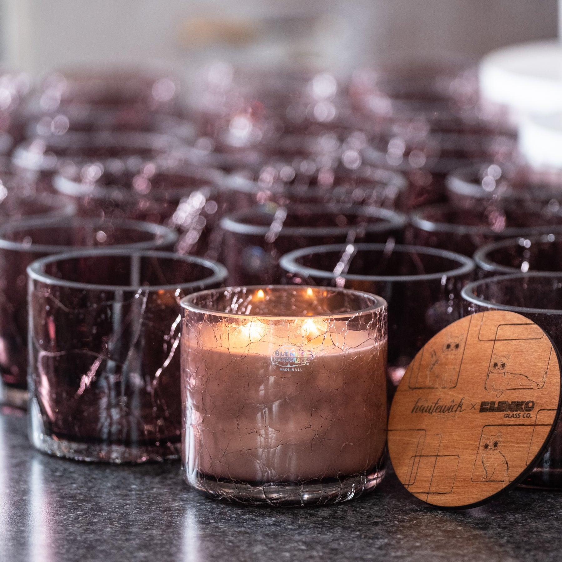 Row of glass candles with a wooden label on a dark surface