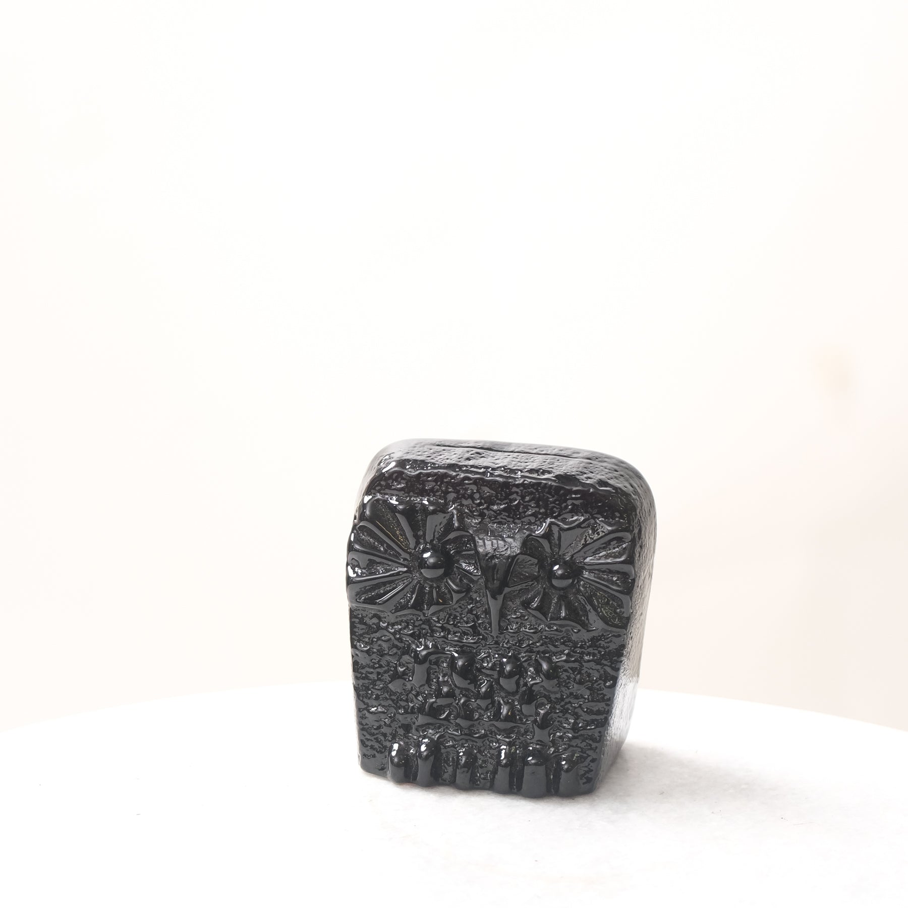Decorative black stone with floral patterns on a white background
