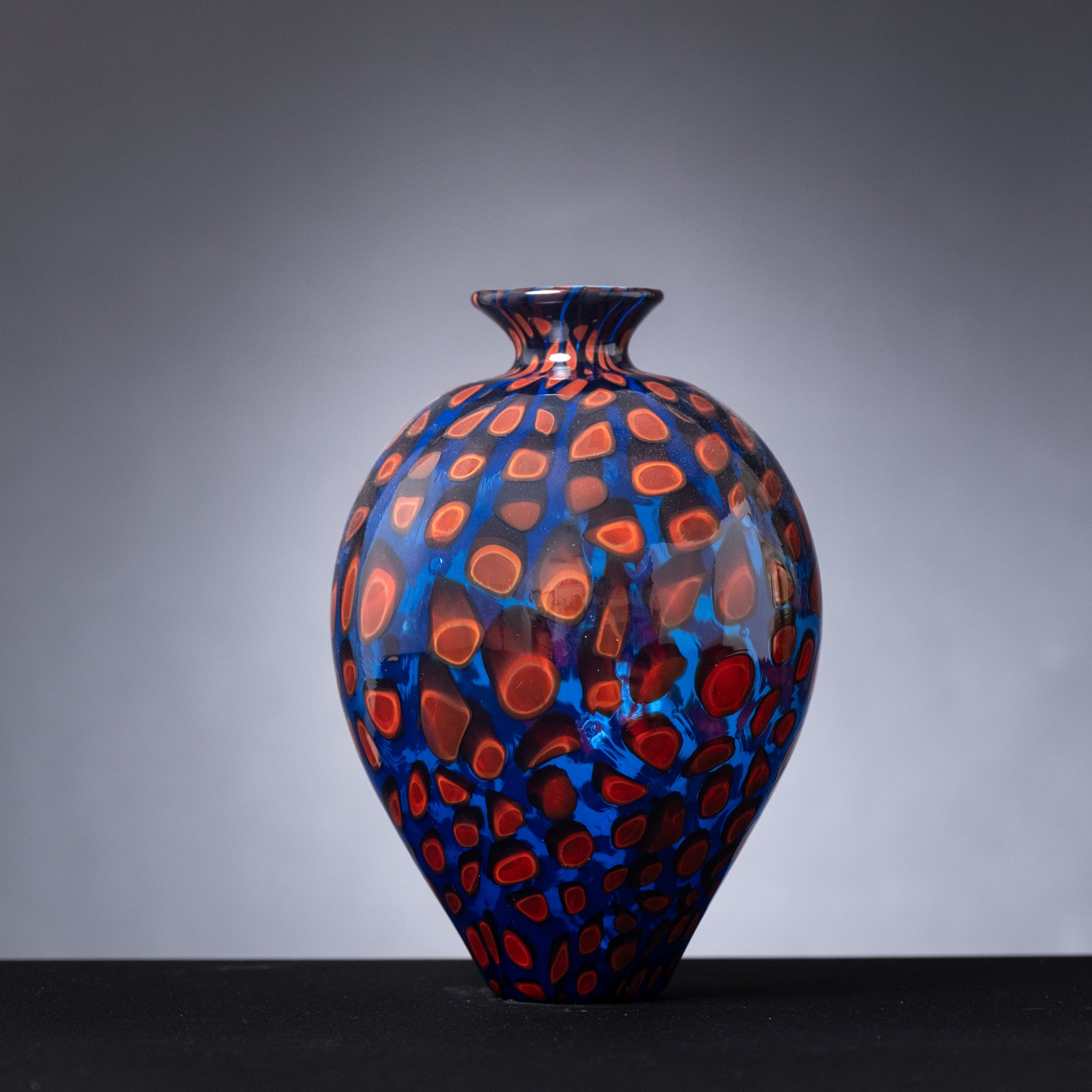 Decorative vase with blue and red pattern on a gray background