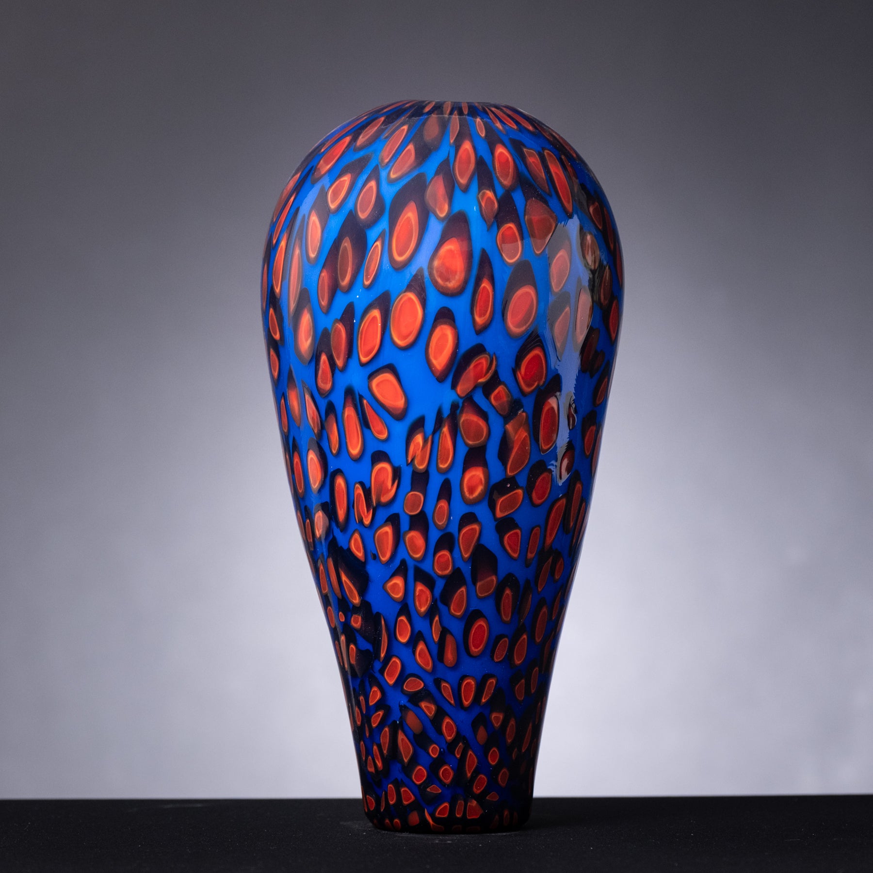 Decorative vase with blue and red pattern on a gray background