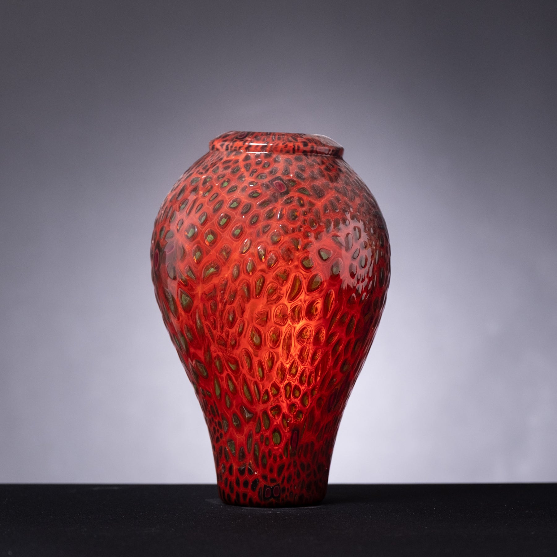 Red textured vase on a gray background