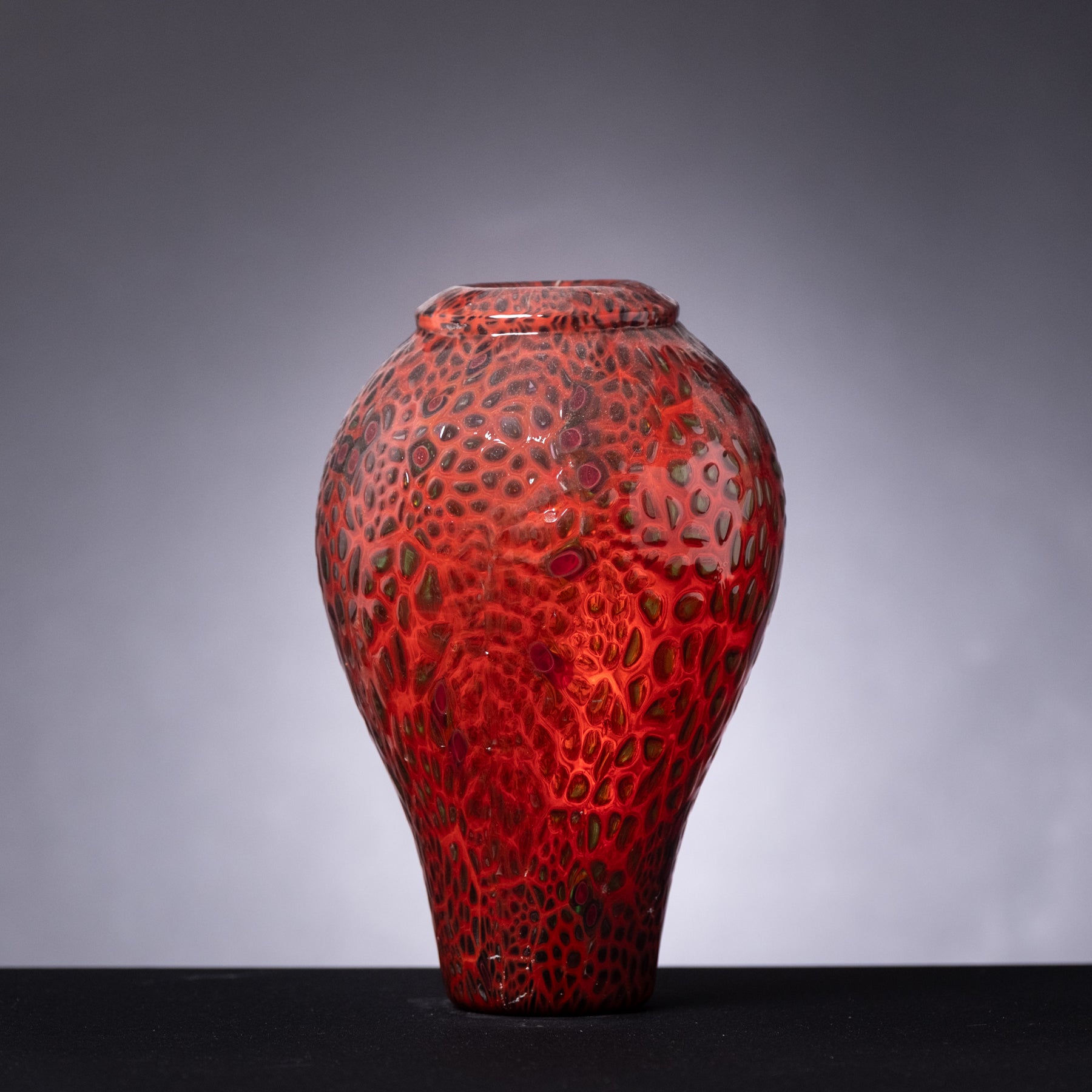 Red textured vase on a gray background
