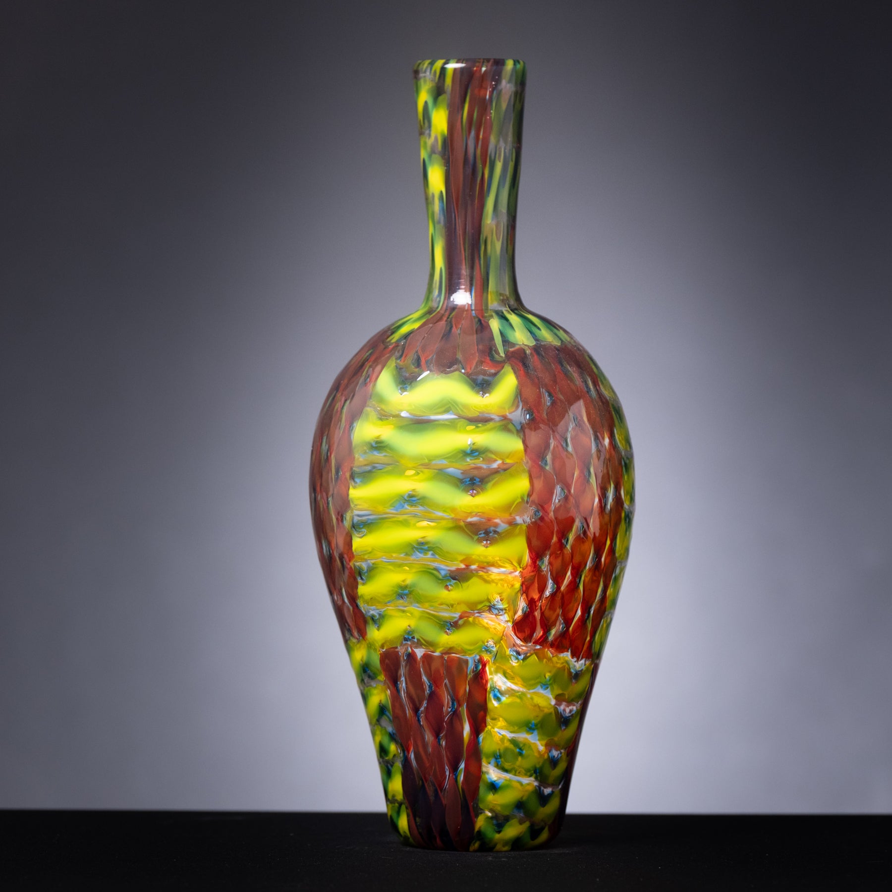 Colorful glass vase with a textured pattern on a gray background