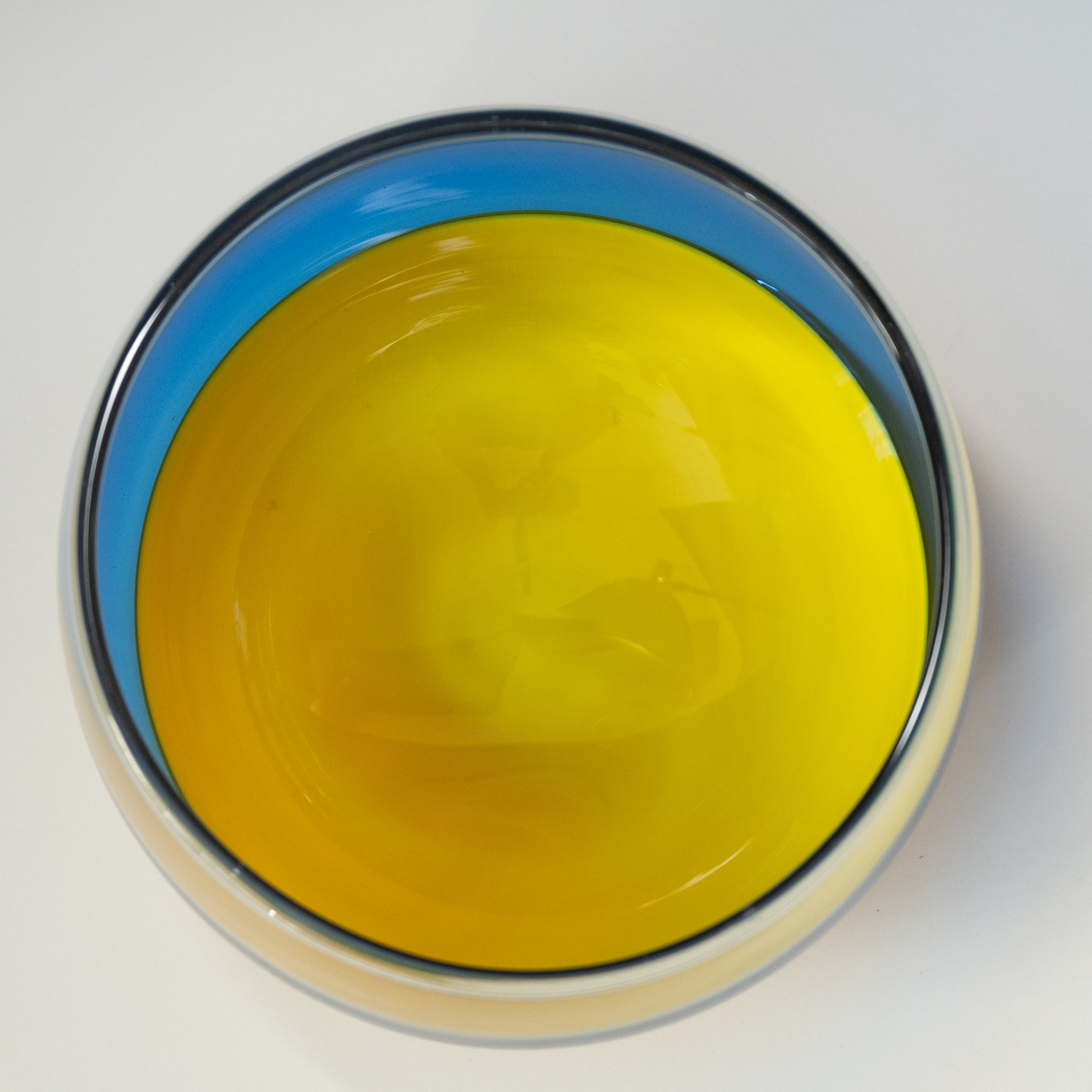Yellow bowl with blue rim on a white background