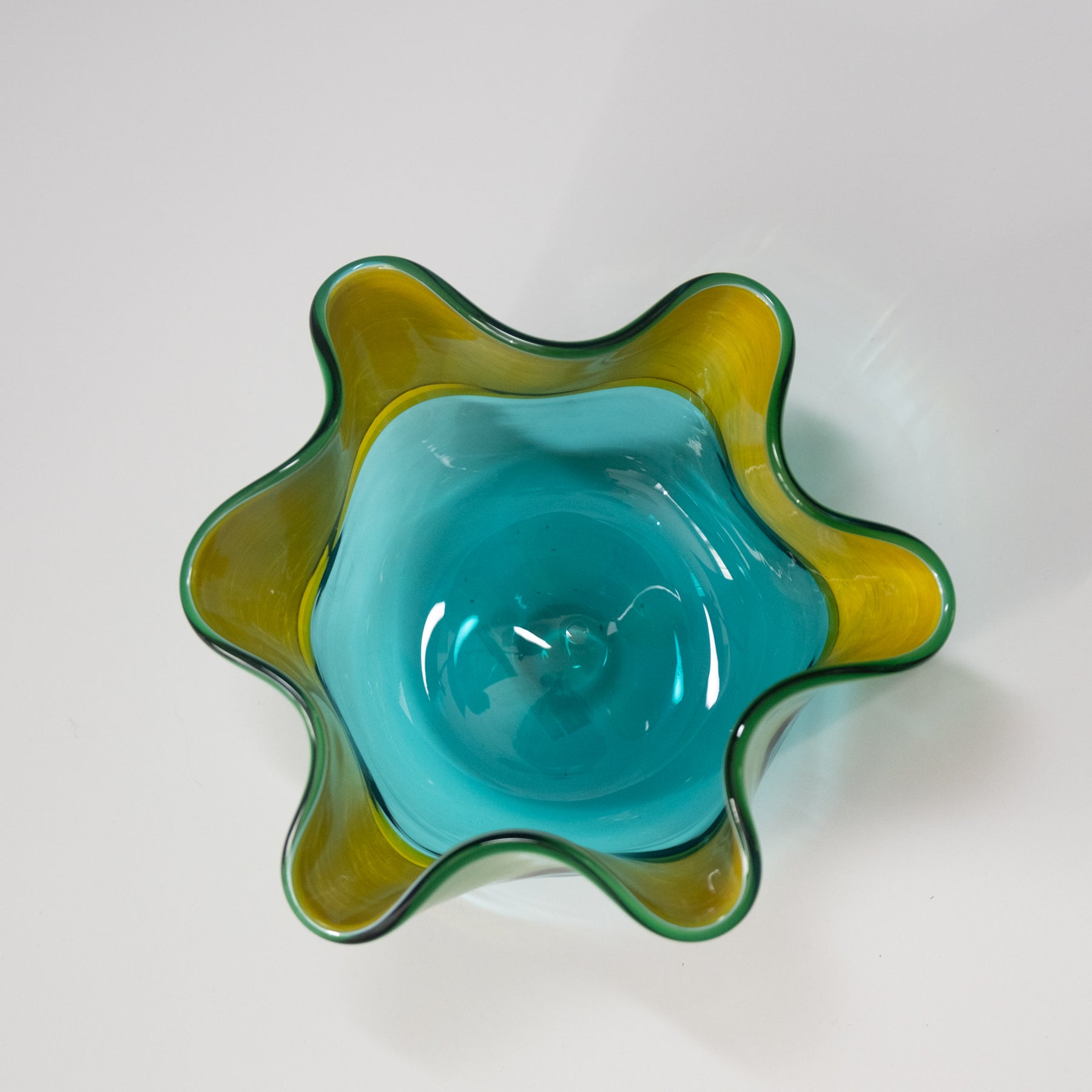 Glass bowl with wavy design in blue and green on a white background