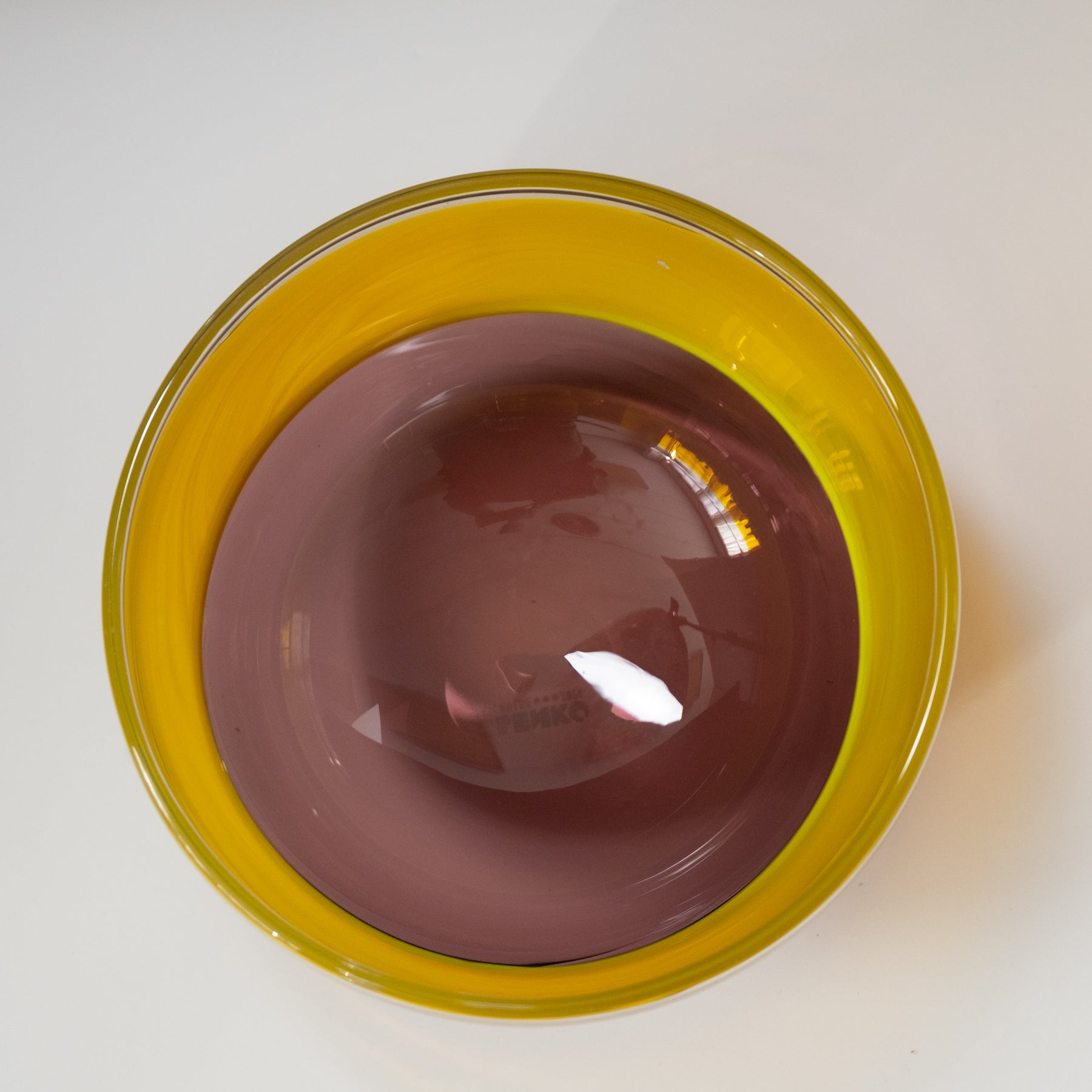 Clear glass bowl with yellow rim on a white background