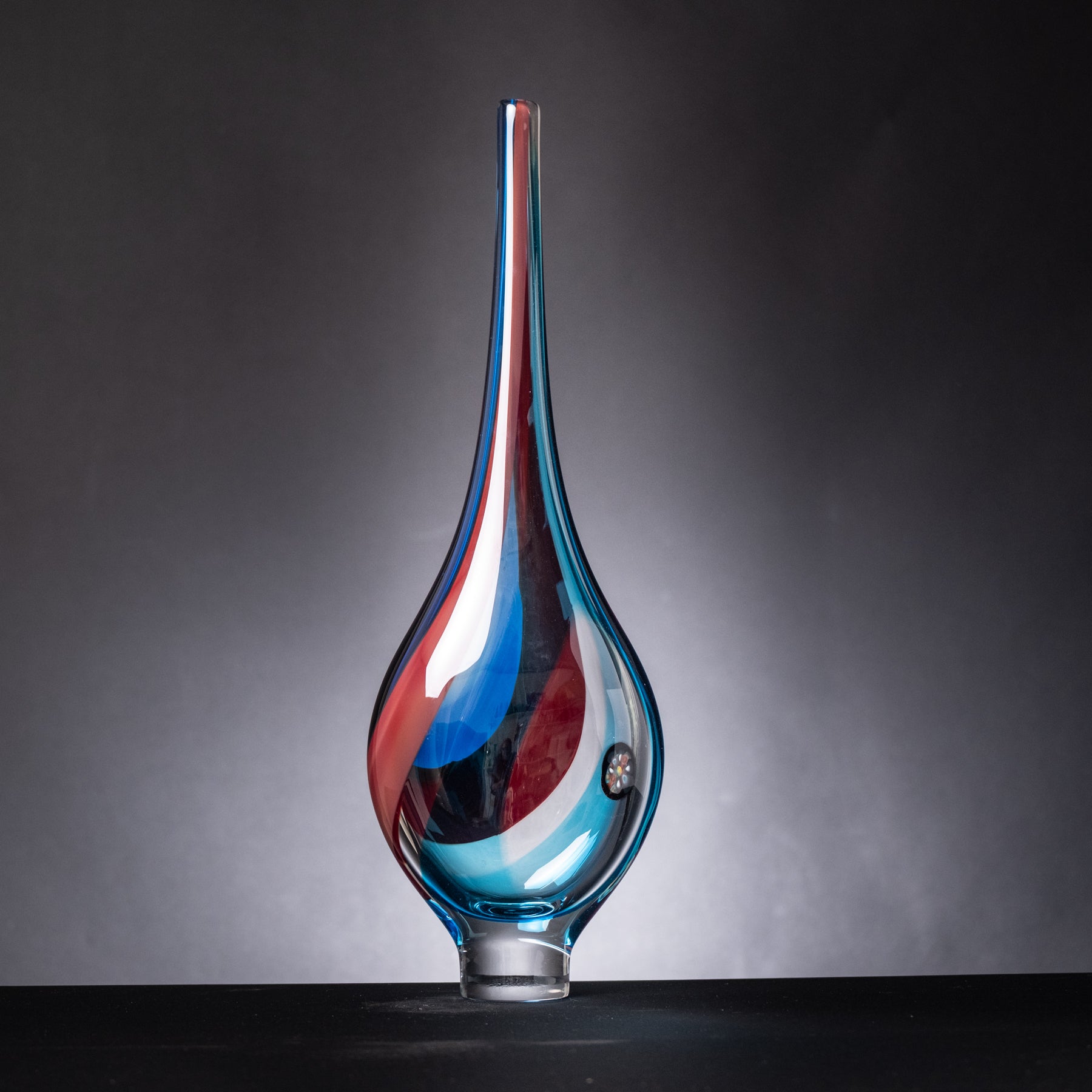Glass vase with blue and red gradient on a dark background