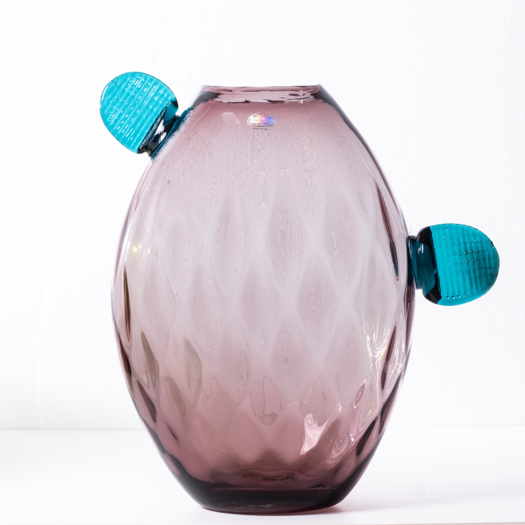 Light purple glass cactus with teal pedals on white background.