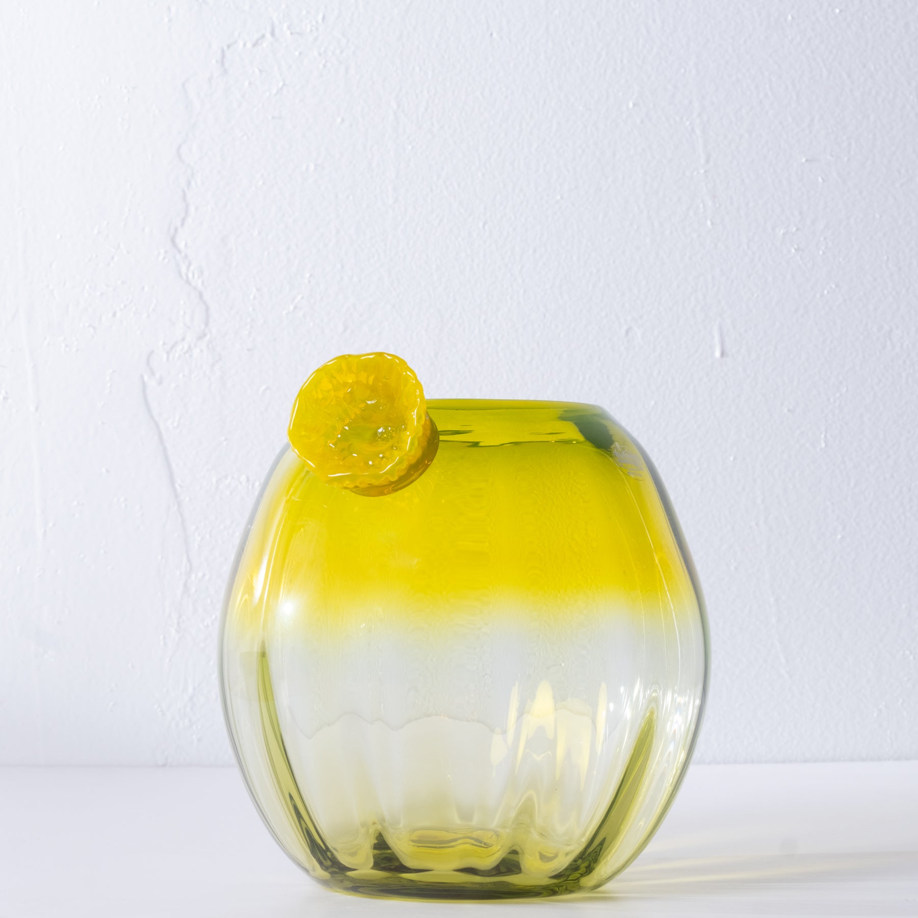 Yellow glass cactus with yellow flower on white background.
