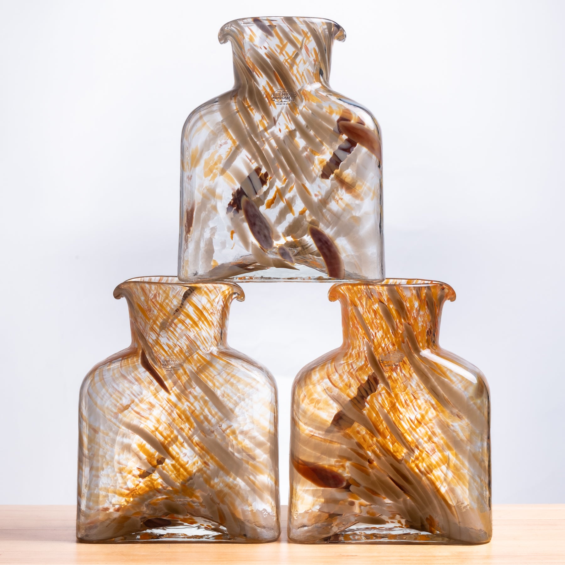 Three glass vases with a swirling pattern on a light background