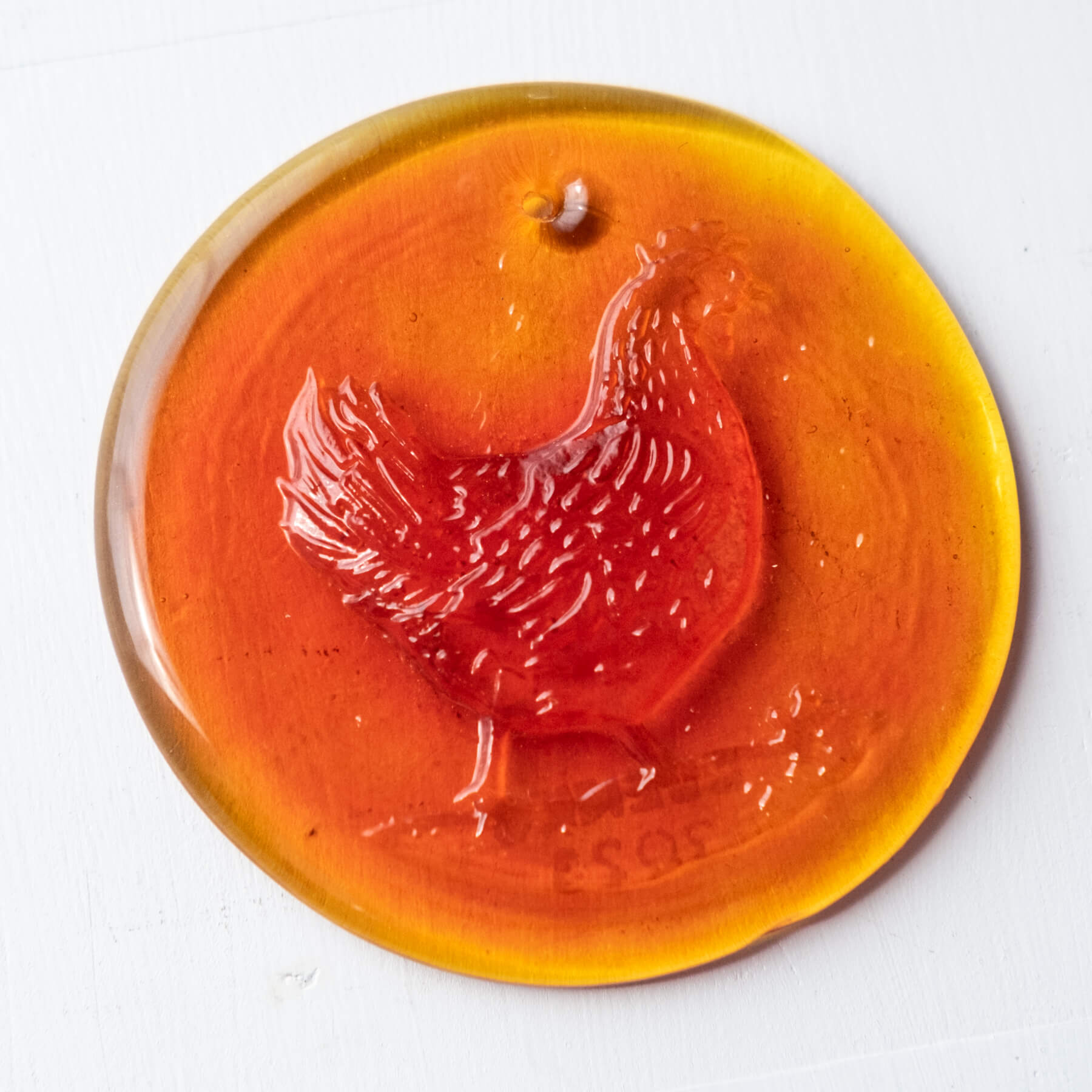 tangerine sun-catcher with a chicken on it