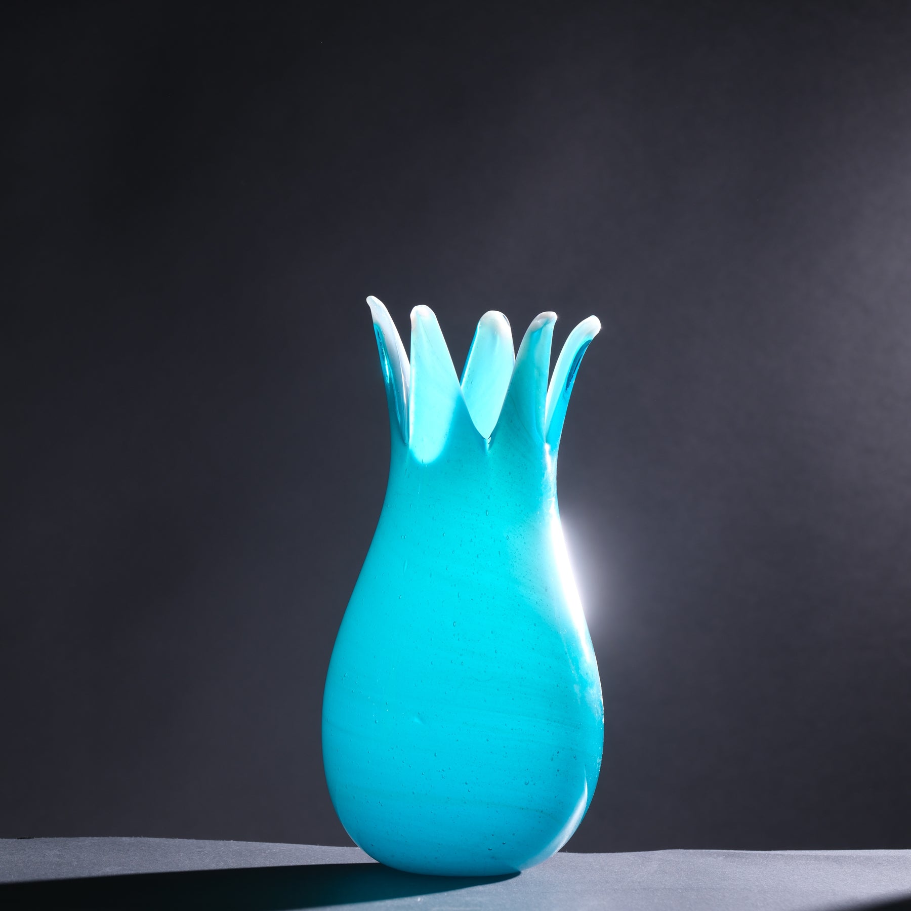 Turquoise pineapple-shaped night light on a dark background
